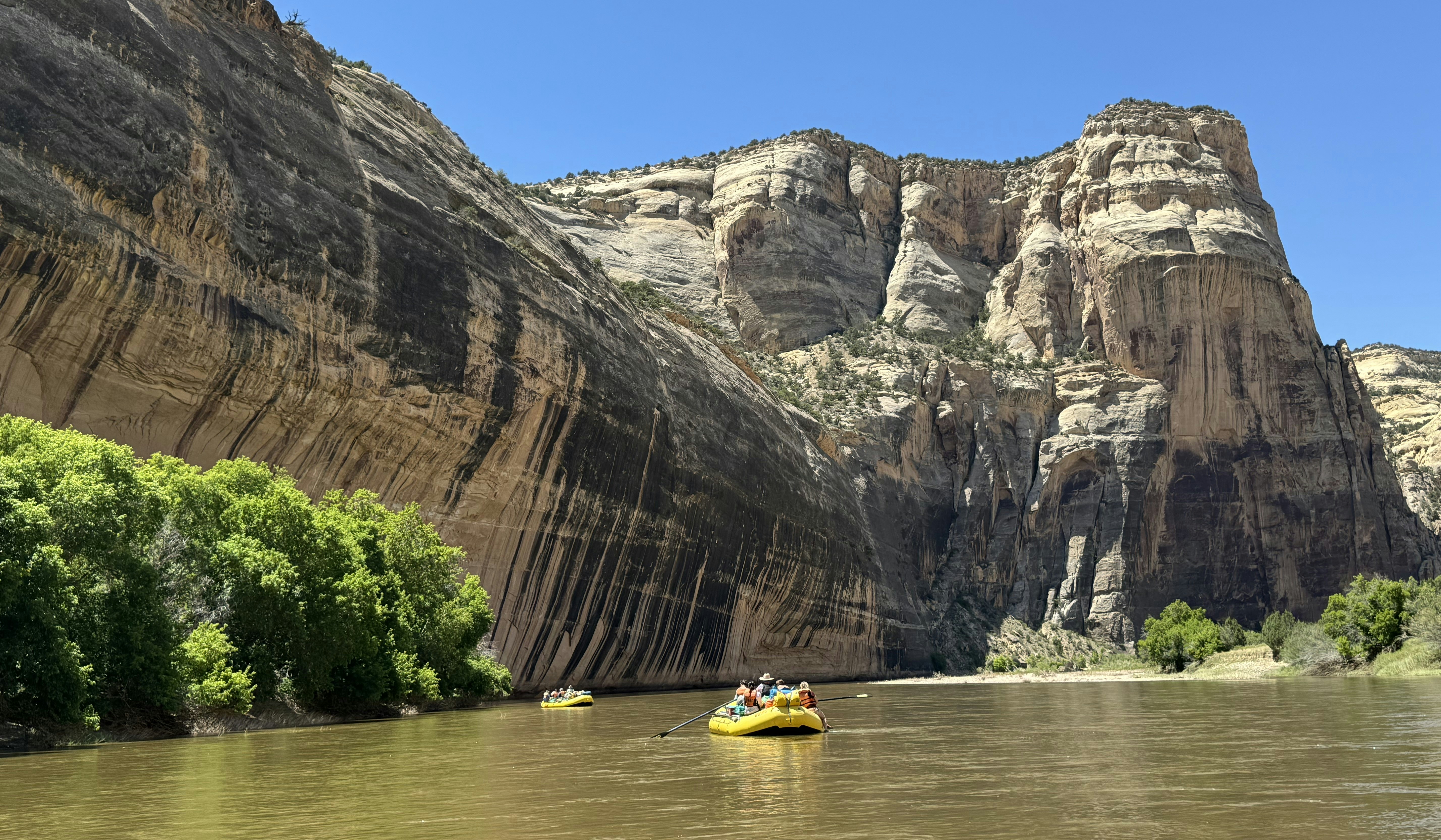 A boat floating down a river surrounded by mountains photo Free Yampa