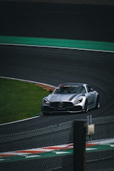 A silver sports car driving on a race track