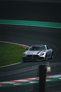 A silver sports car driving on a race track