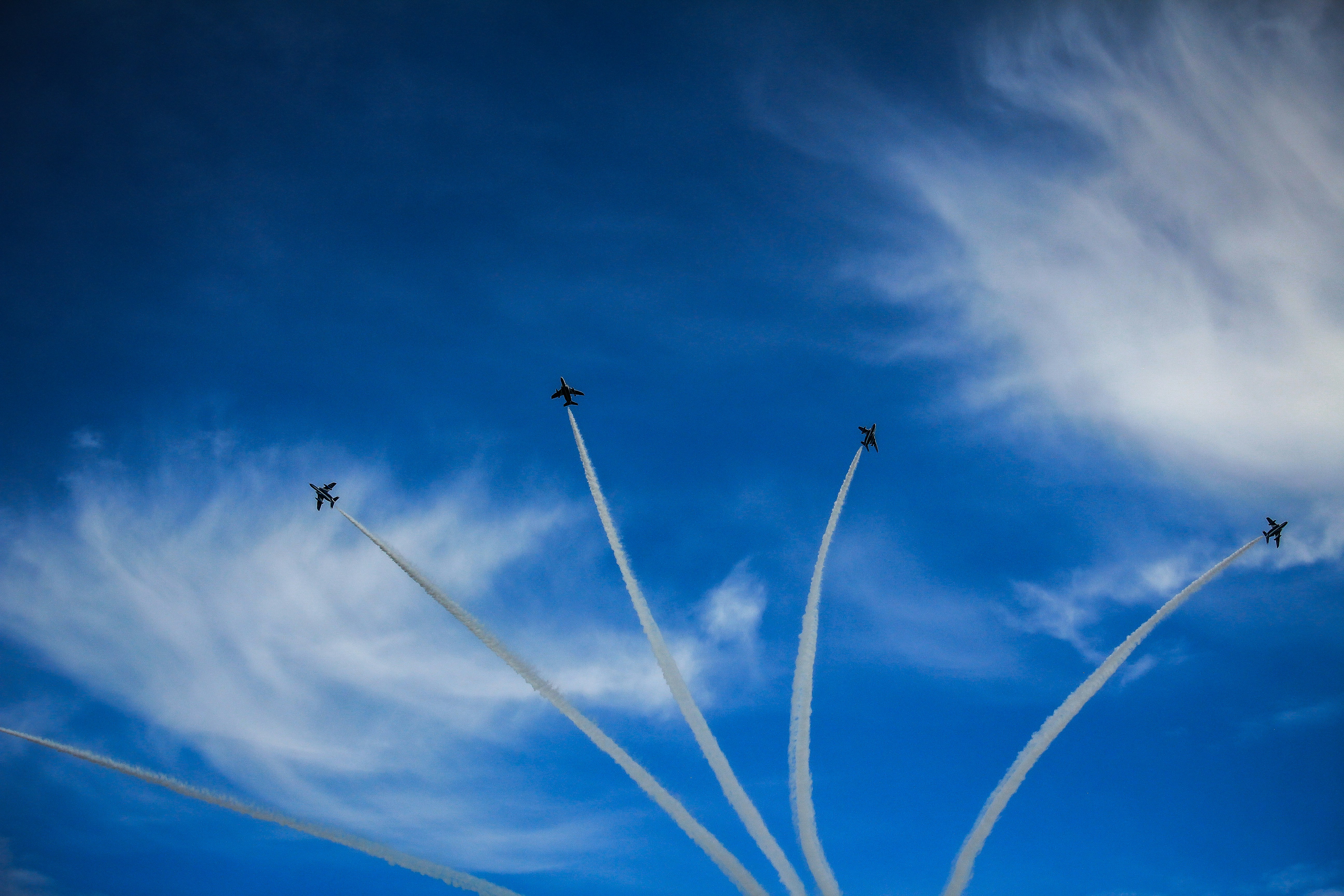 A group of airplanes flying through a blue sky