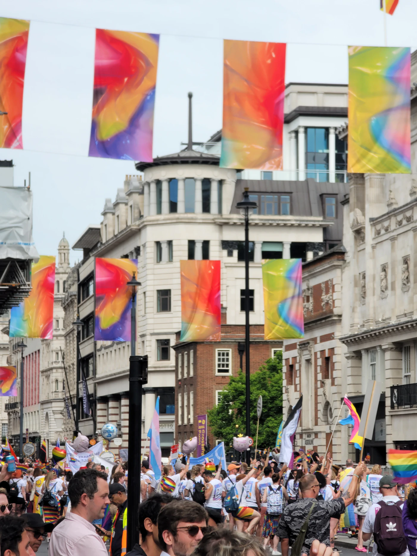 Crowd holding rainbow flags at a Pride parade