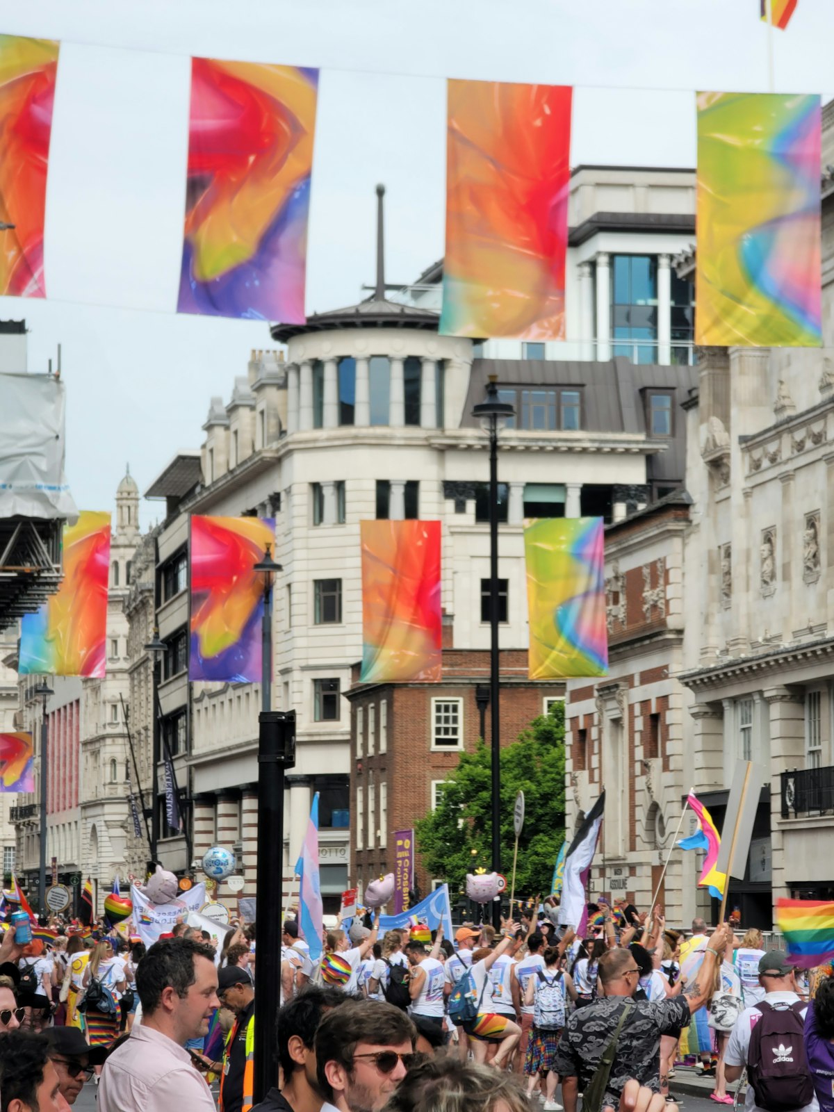 London June — a crowd carrying rainbow flags along the street at London Pride 2024
