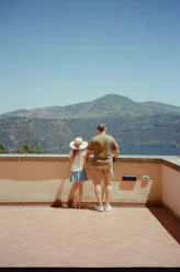 A man and a little girl standing on a balcony