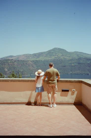A man and a little girl standing on a balcony