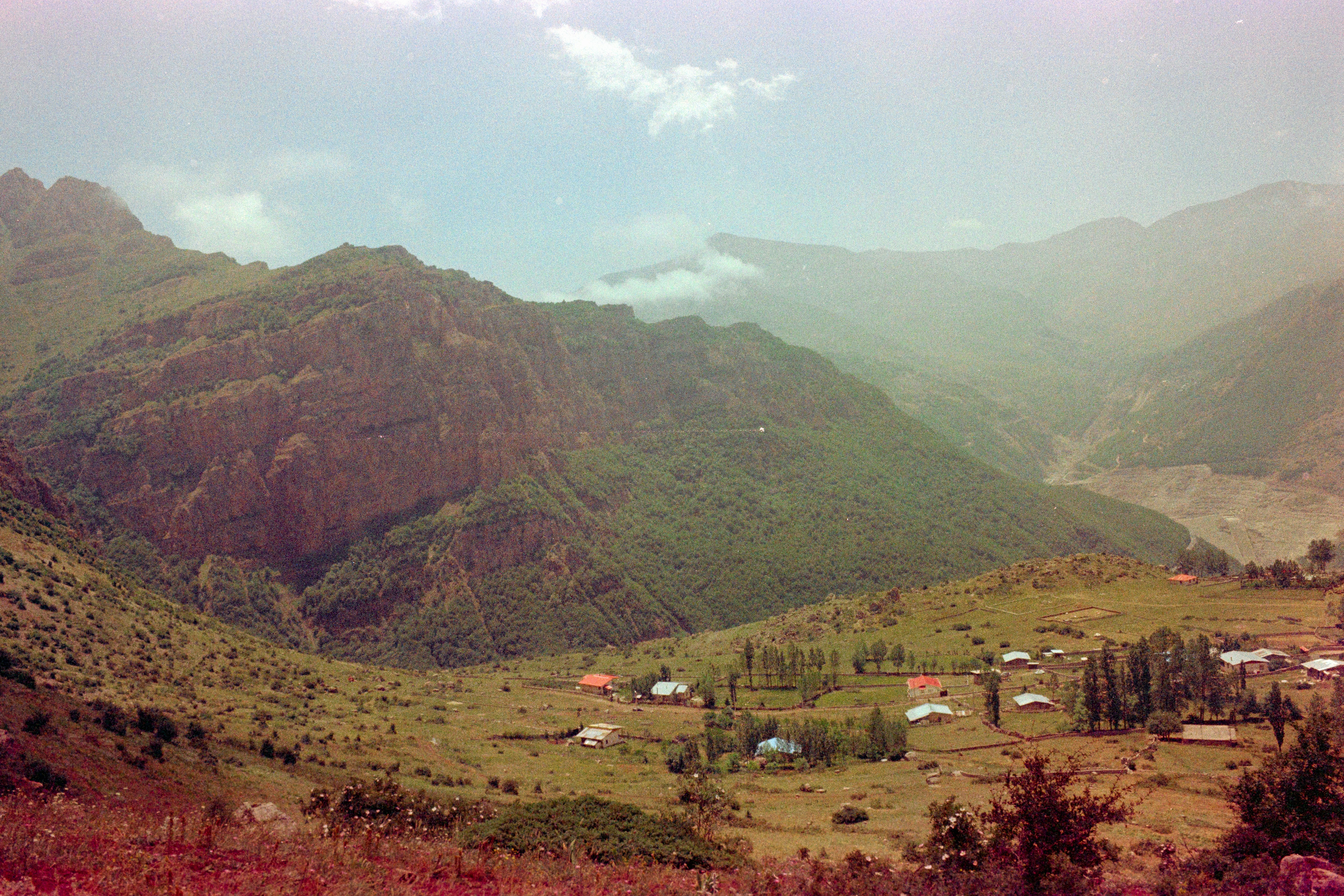 A view of a valley with mountains in the background