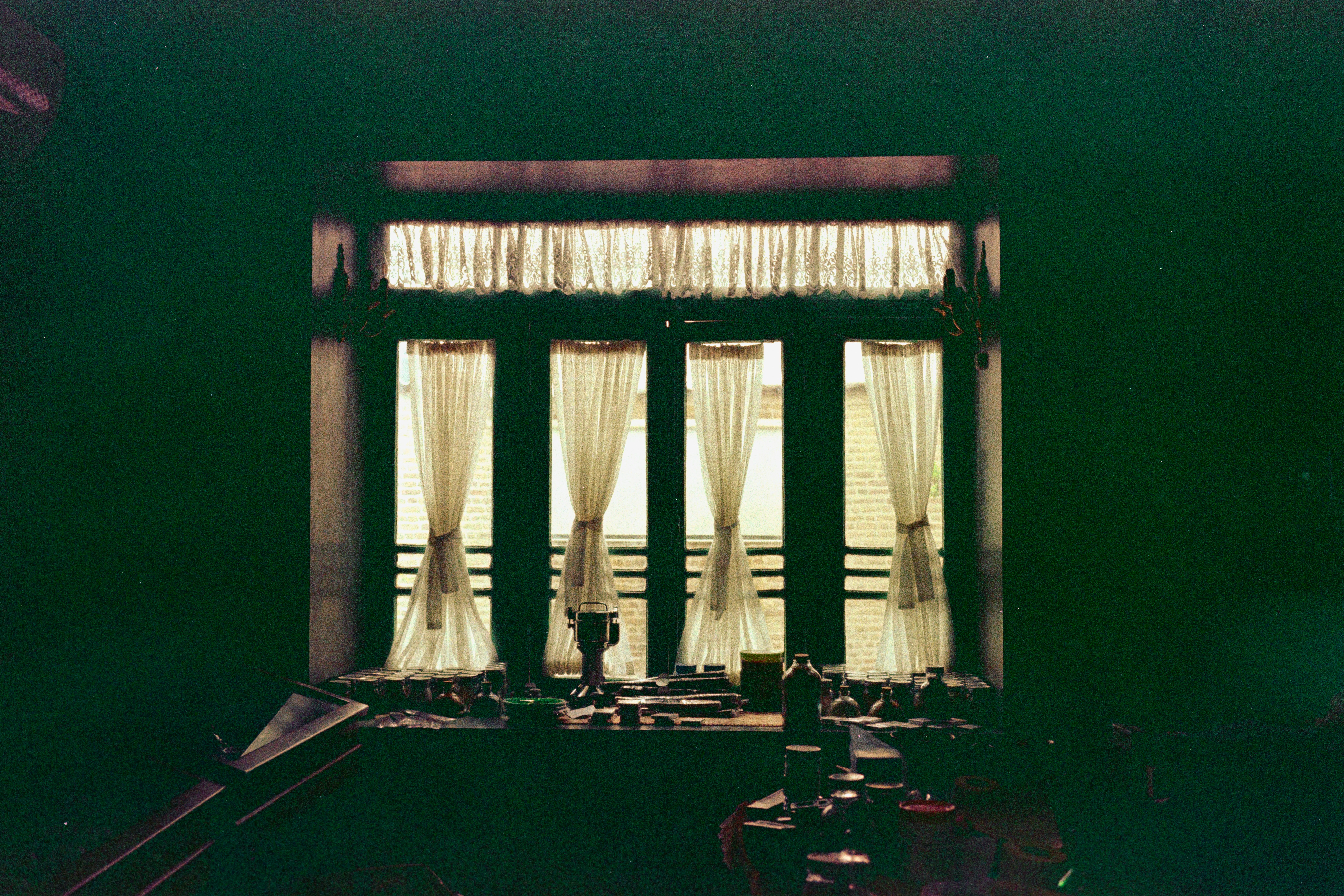 A dark room with a window and curtains