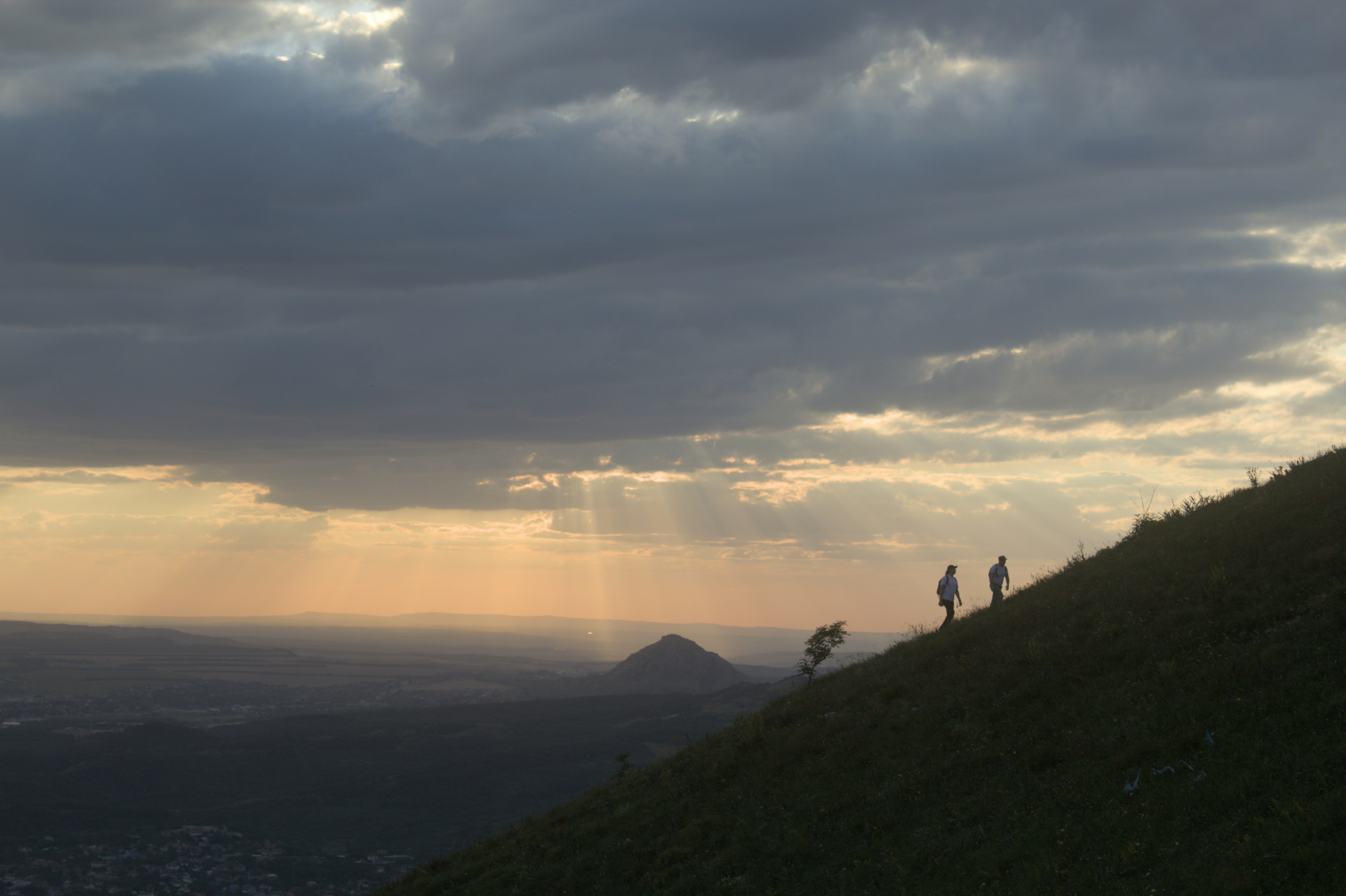 A group of people standing on top of a lush green hillside