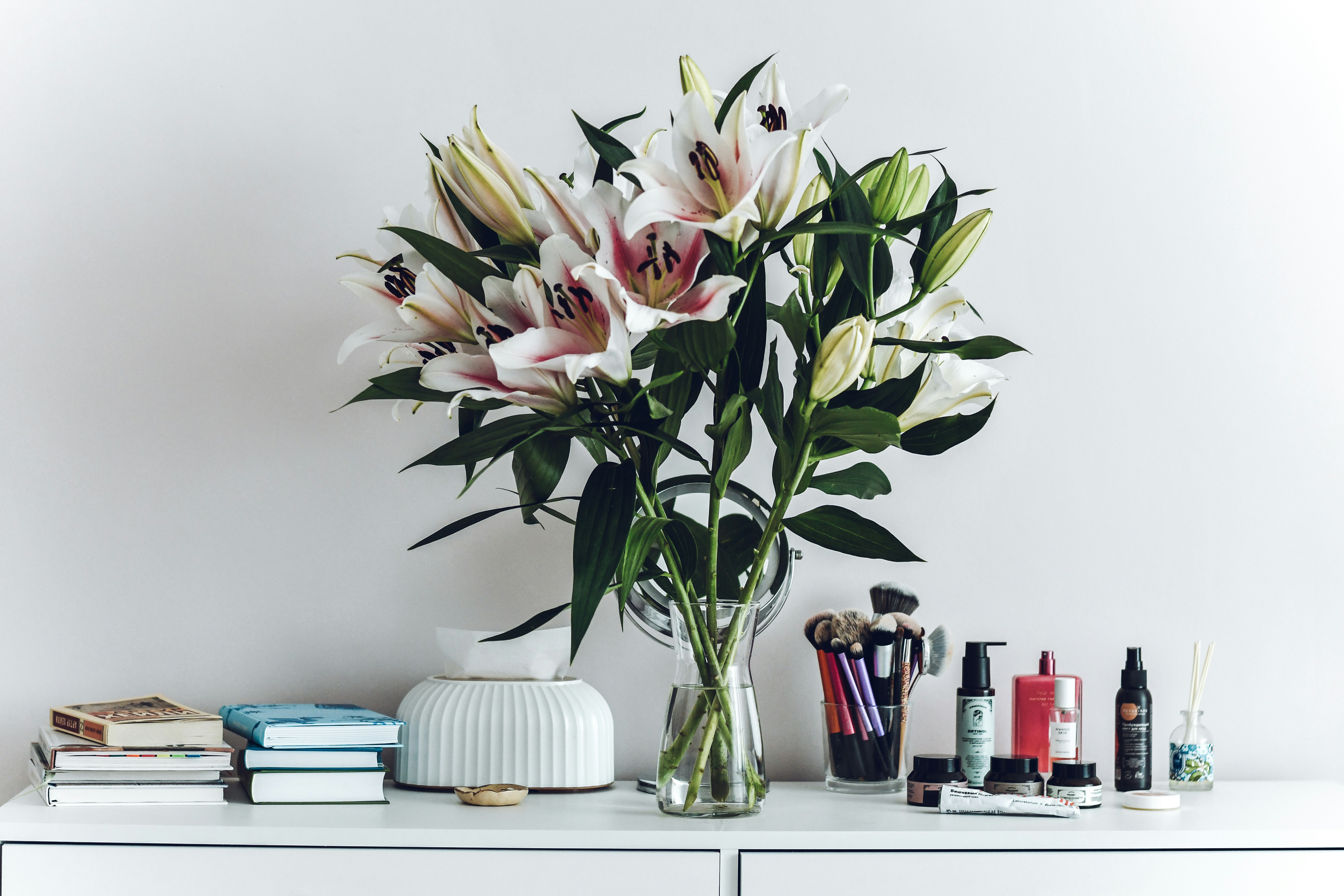 A vase filled with flowers sitting on top of a white dresser