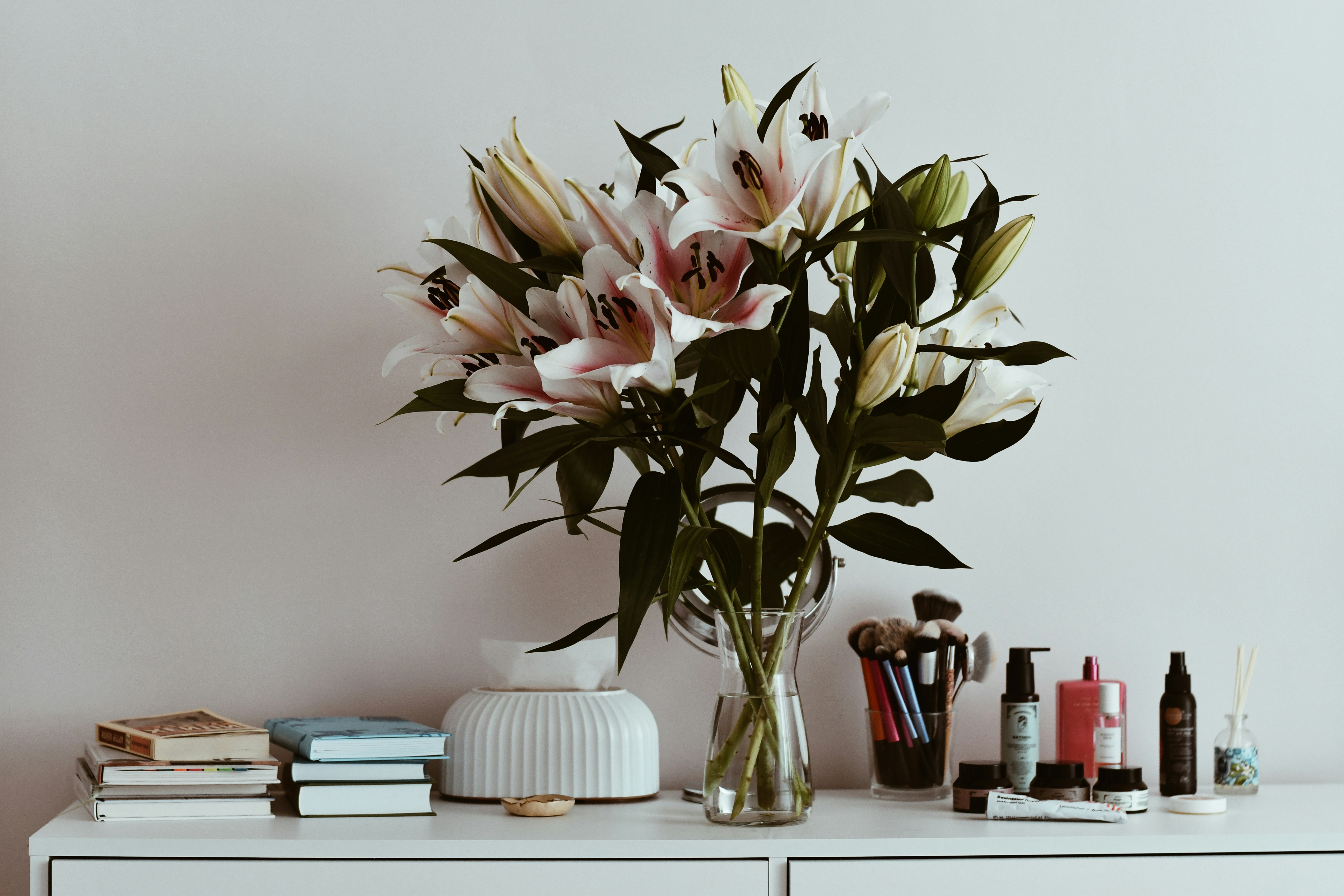 A vase of flowers sitting on top of a white dresser