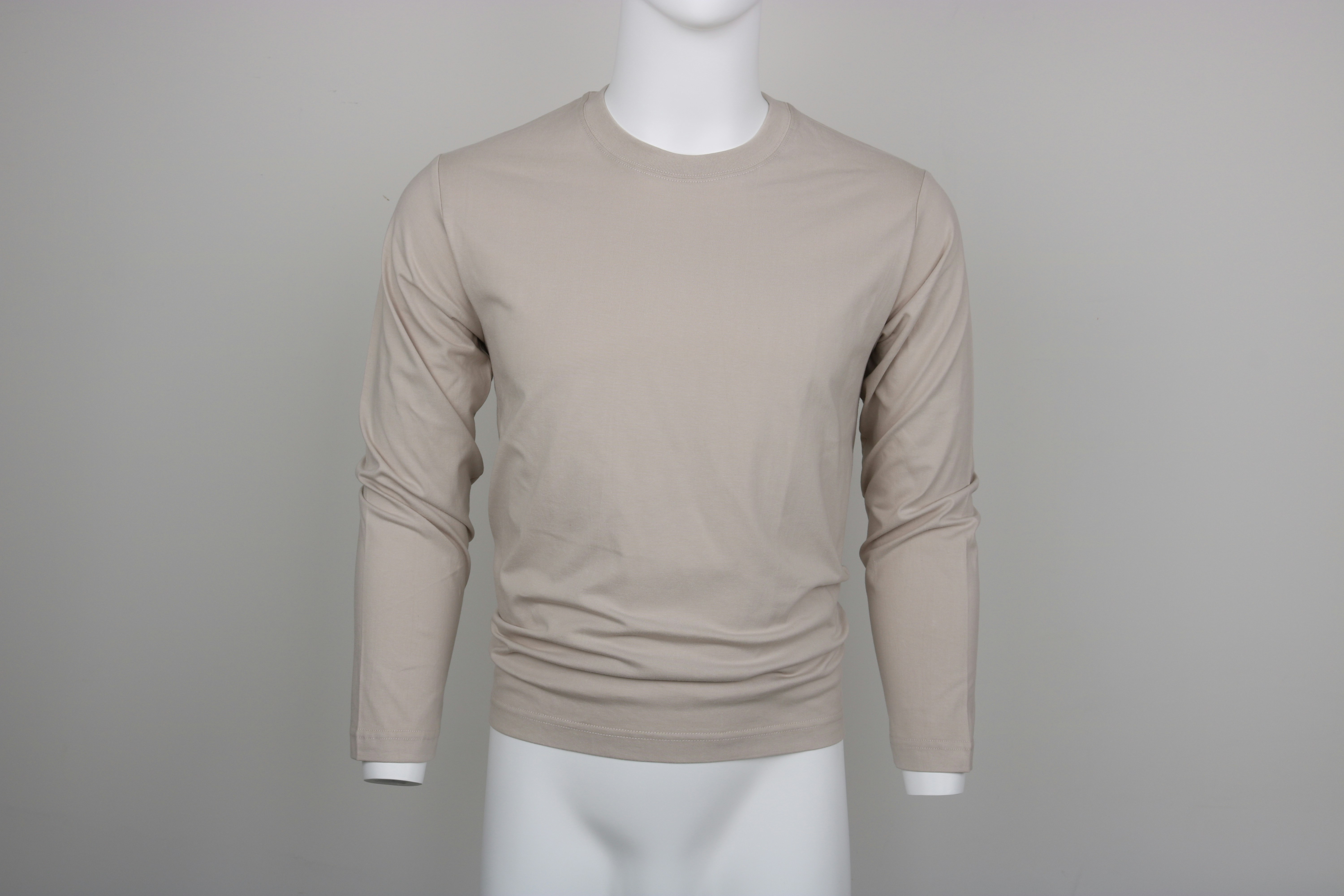 เสื้อยืดแขนยาวสีเบจสวมบนหุ่นโชว์สีขาว ถ่ายหน้าตรงบนพื้นสีเทา