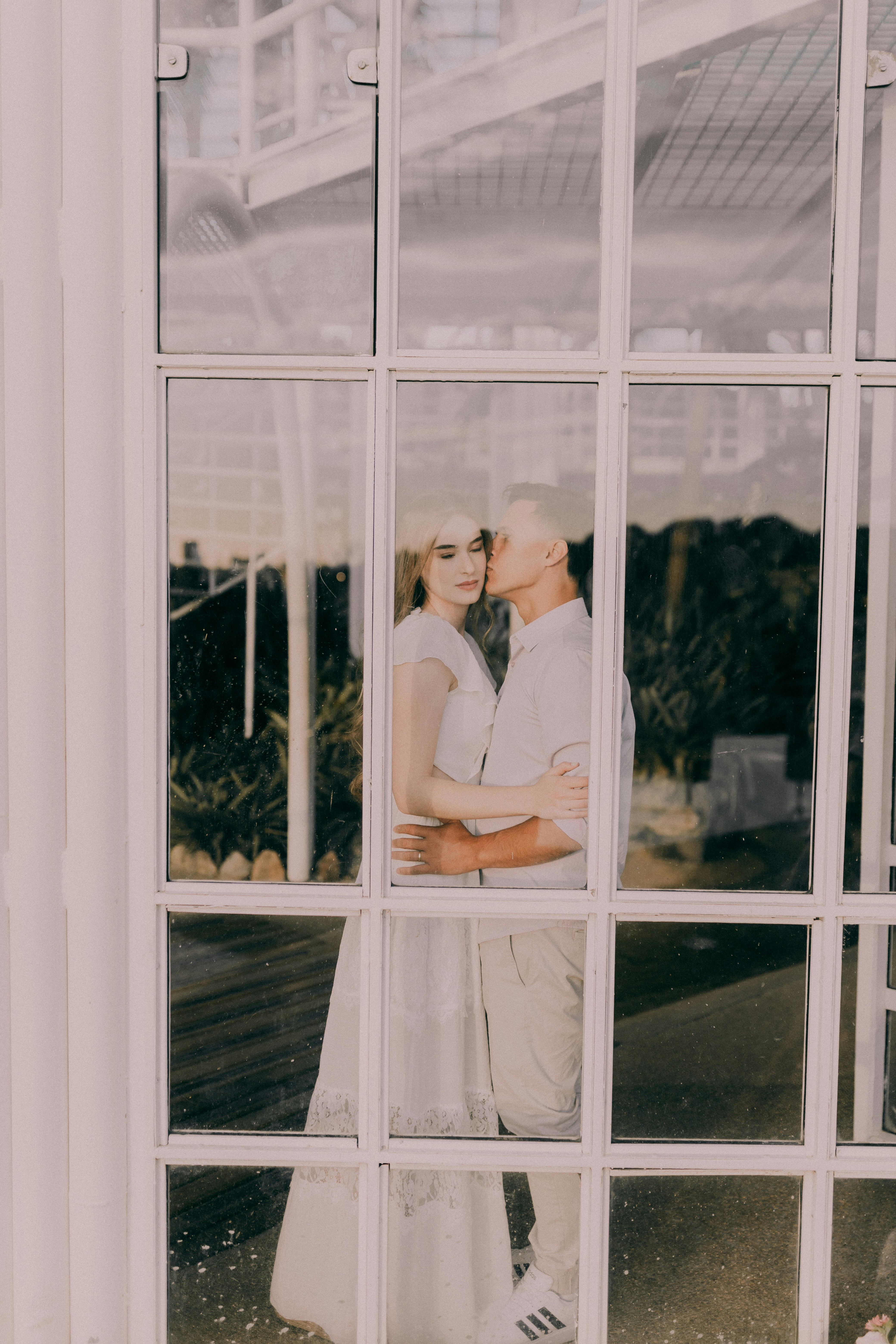 A man and a woman standing in front of a window photo – Free Grey Image ...