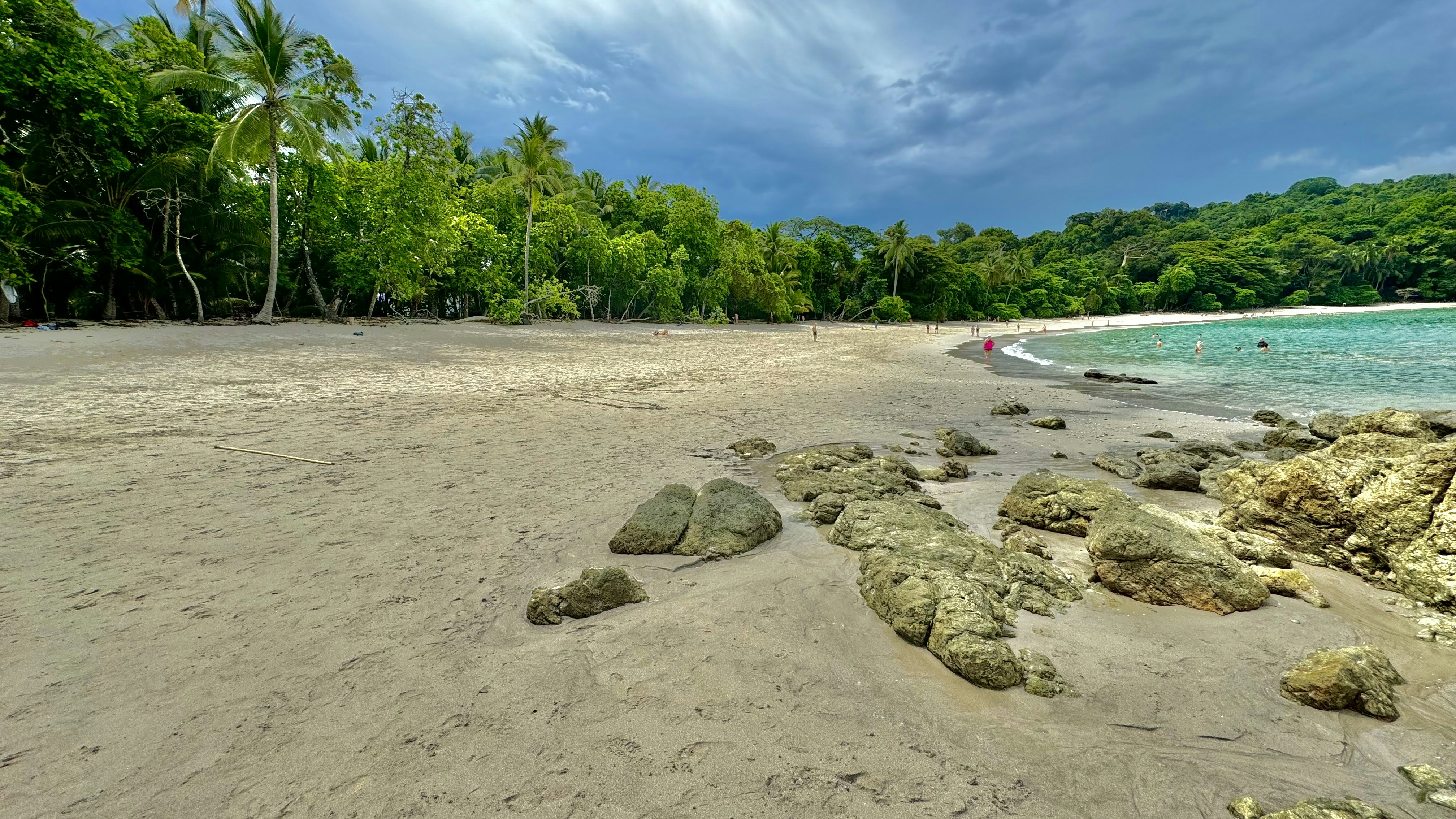 A sandy beach next to the ocean under a cloudy sky