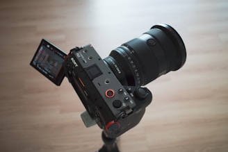 A camera attached to a tripod on a wooden table