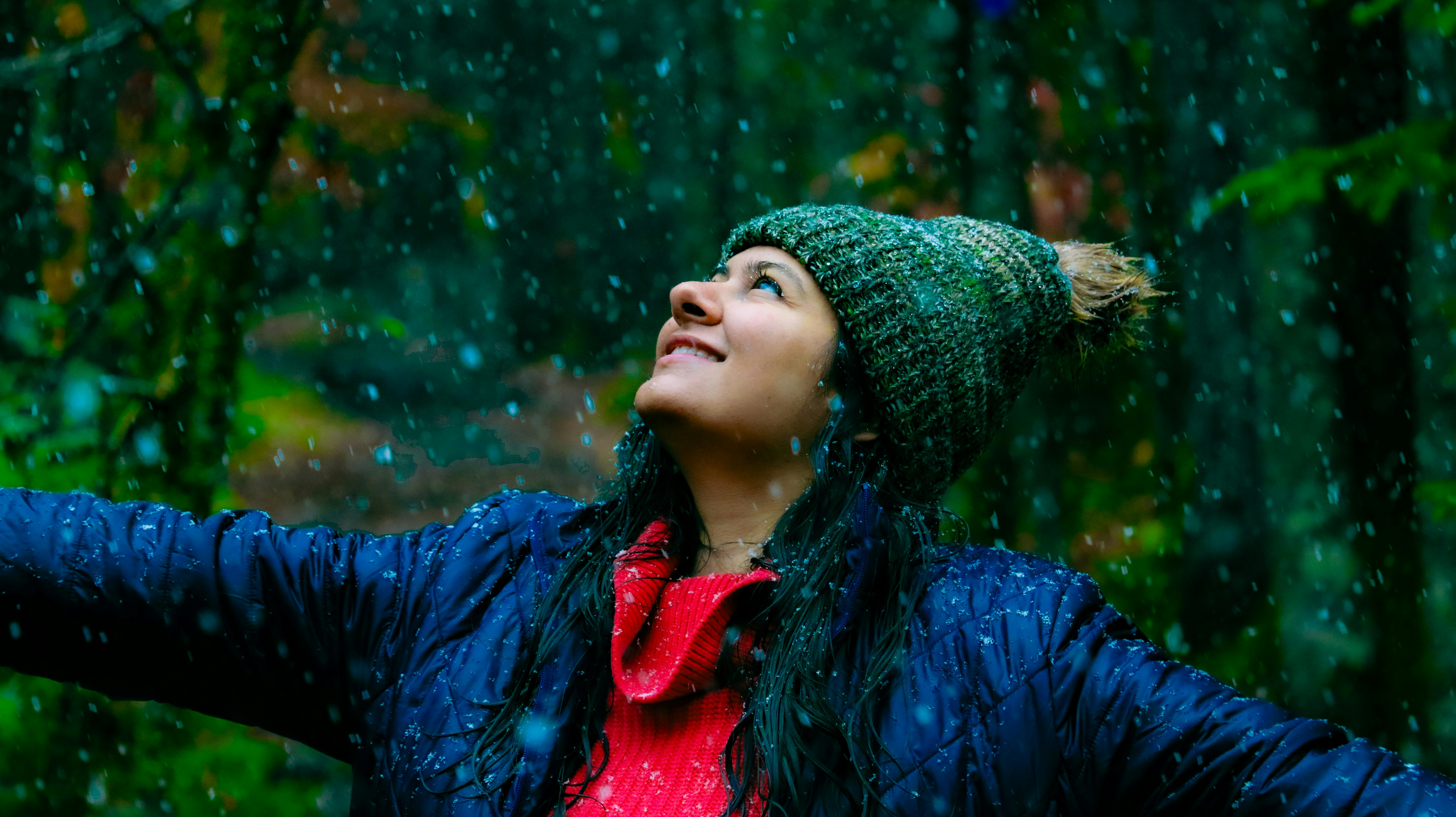 A woman standing in the rain with her arms outstretched