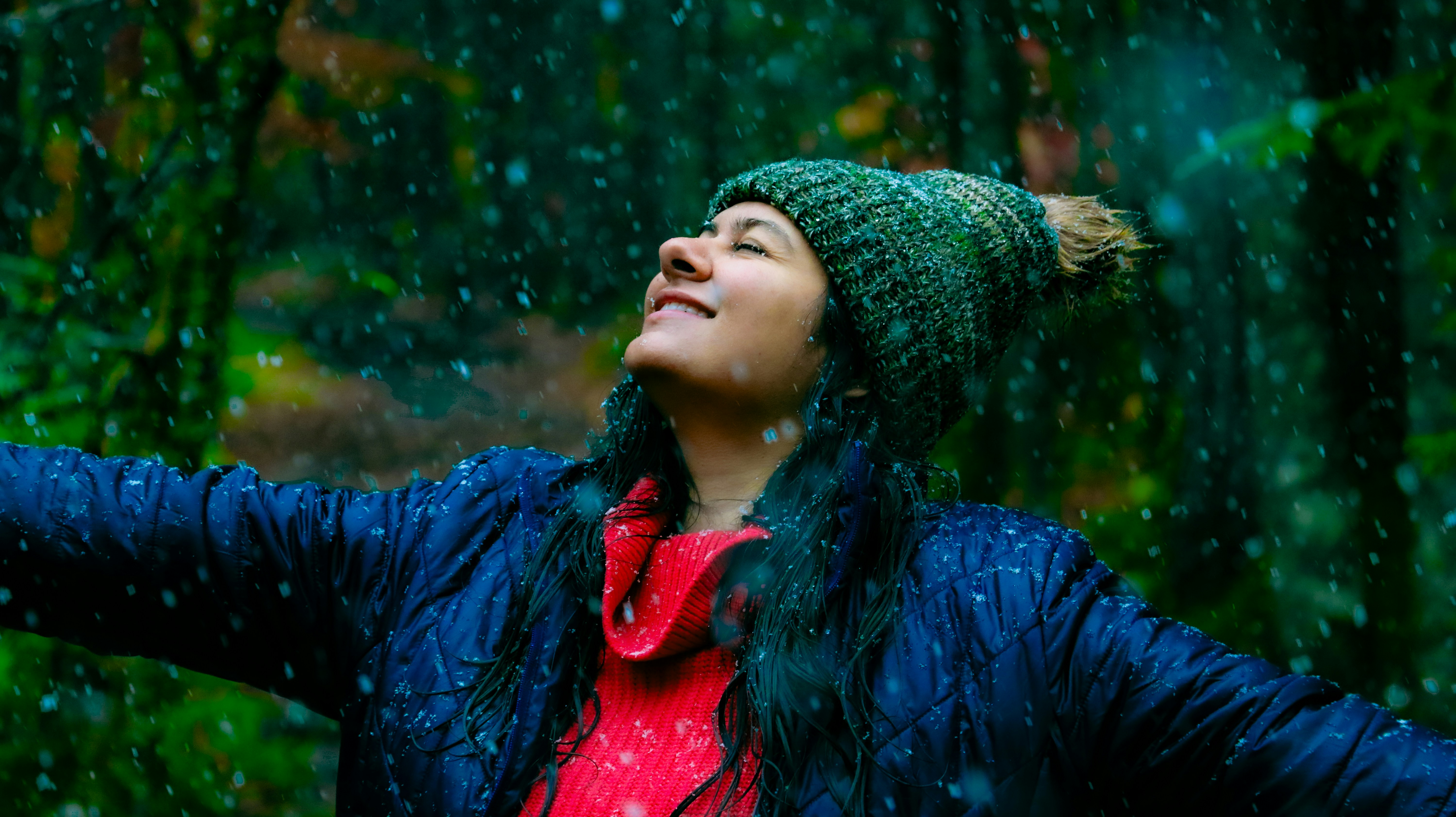A woman standing in the rain with her arms outstretched