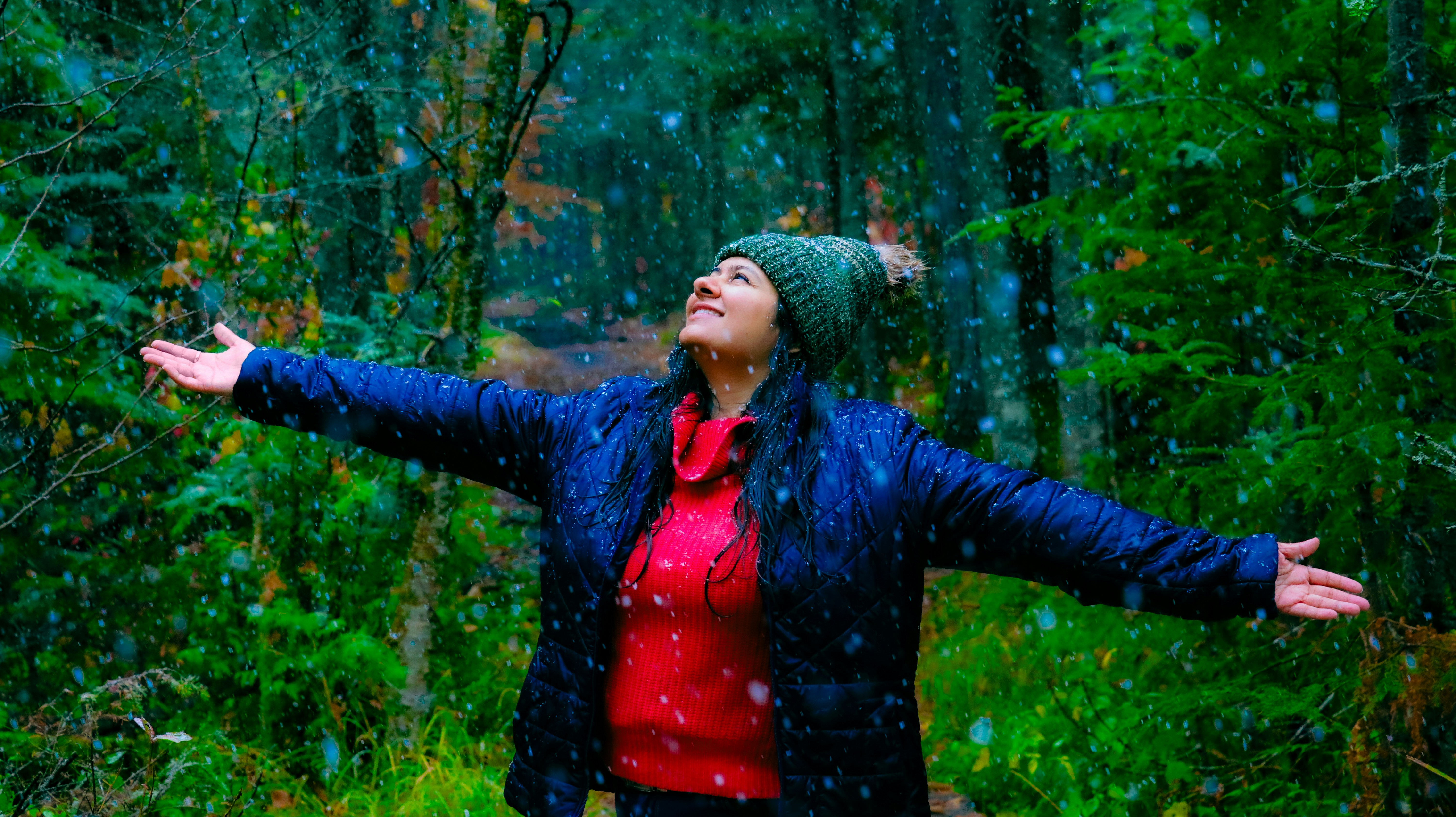 A woman standing in the rain with her arms outstretched