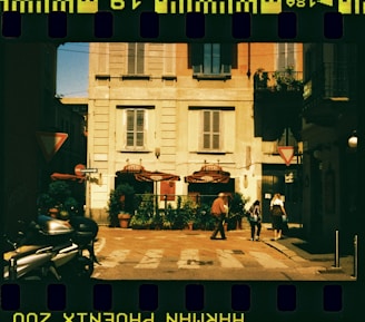 A film strip with a picture of a person walking in front of a building