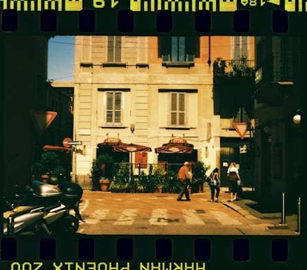 A film strip with a picture of a person walking in front of a building
