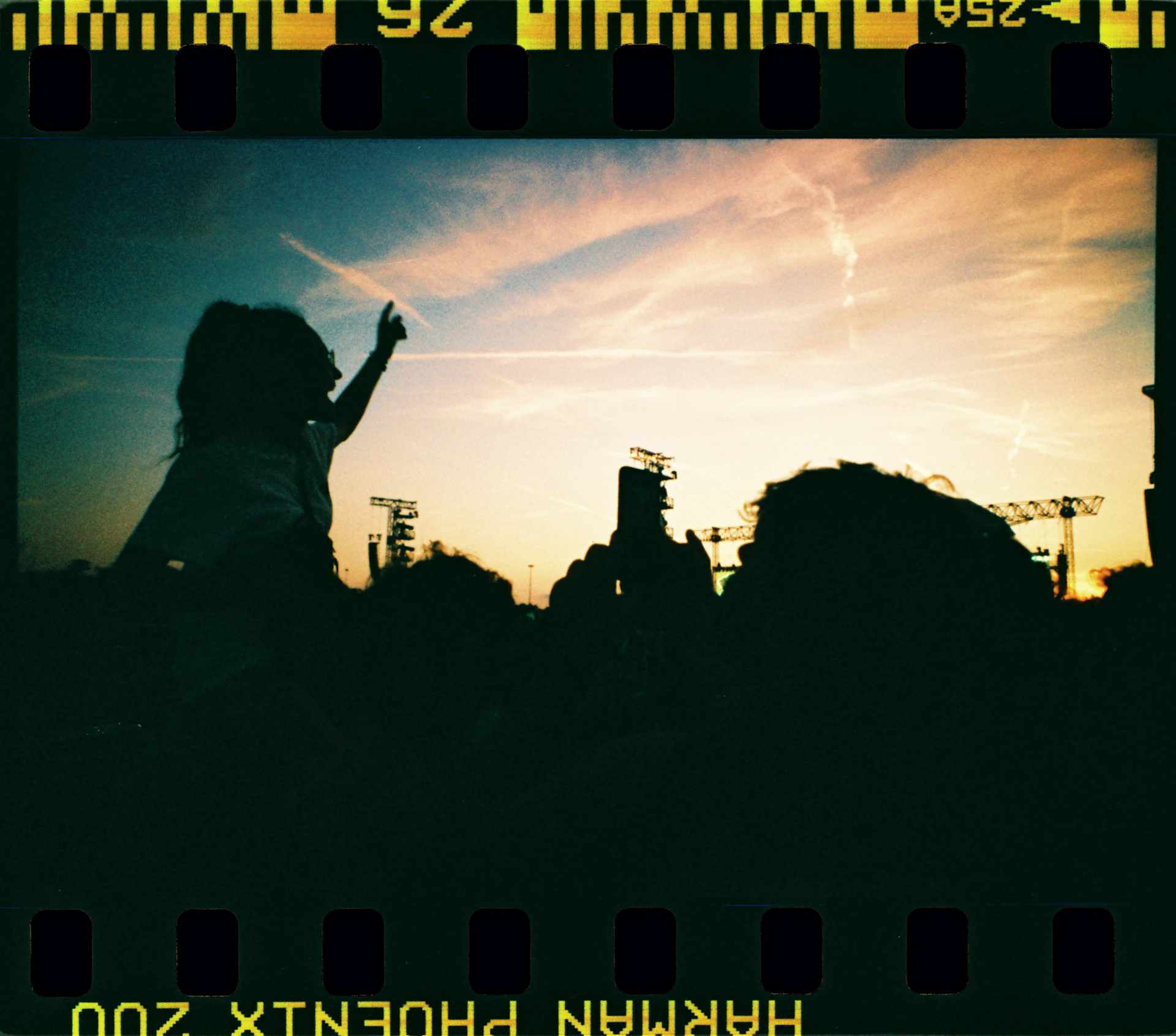 A picture of a person standing in front of a sunset