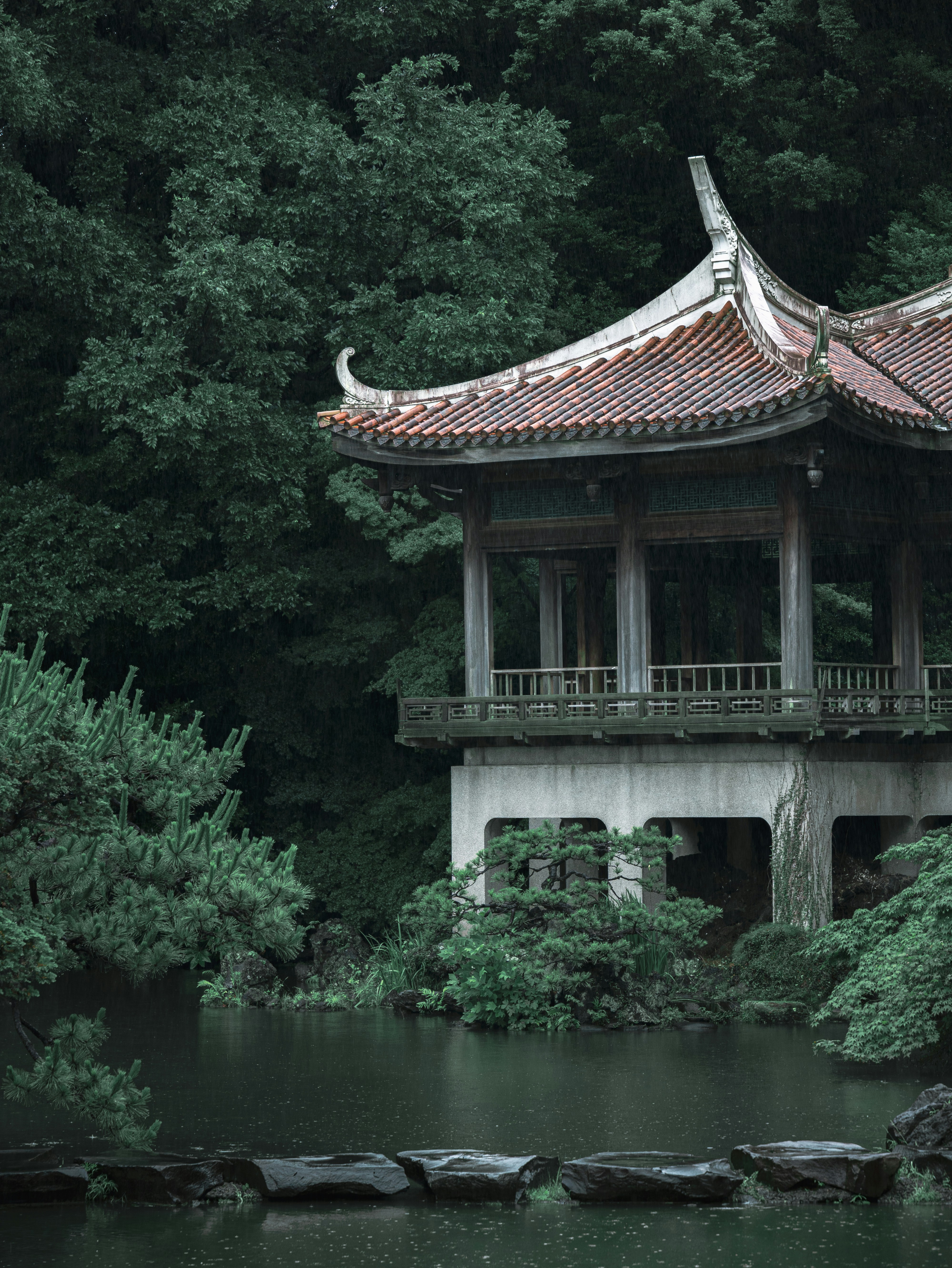 A building in the middle of a pond surrounded by trees