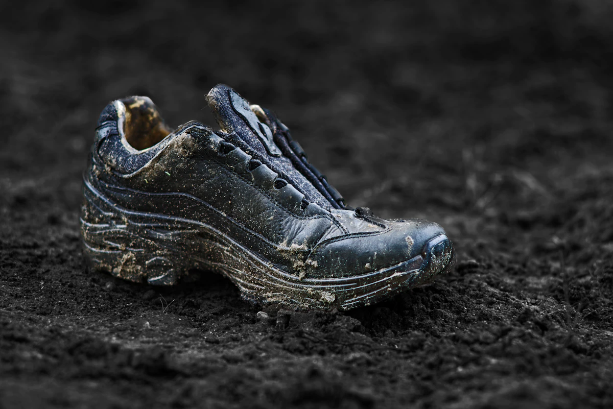 Dirty trail running shoes on a rugged dirt path