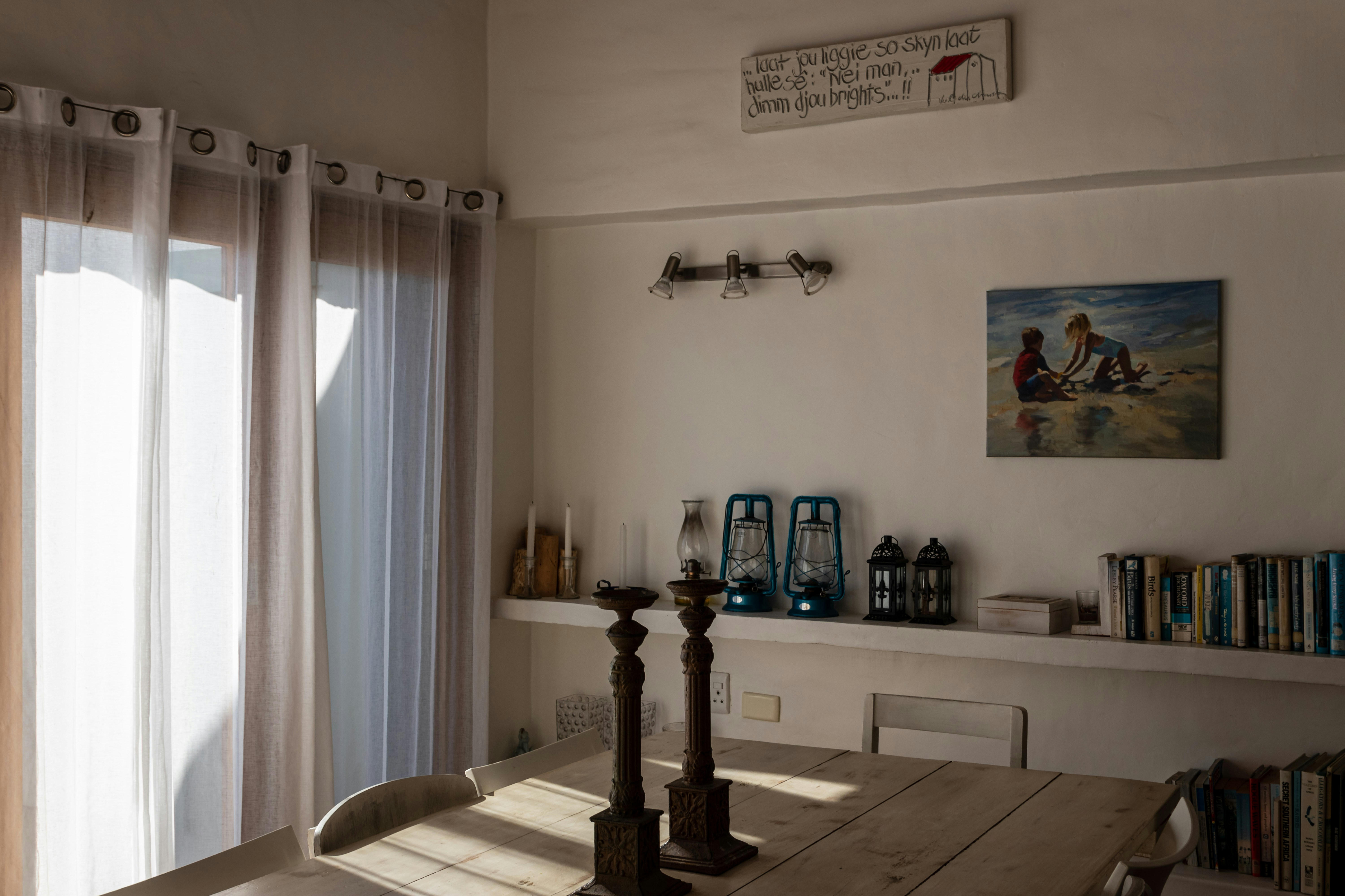 A dining room with a table and a book shelf