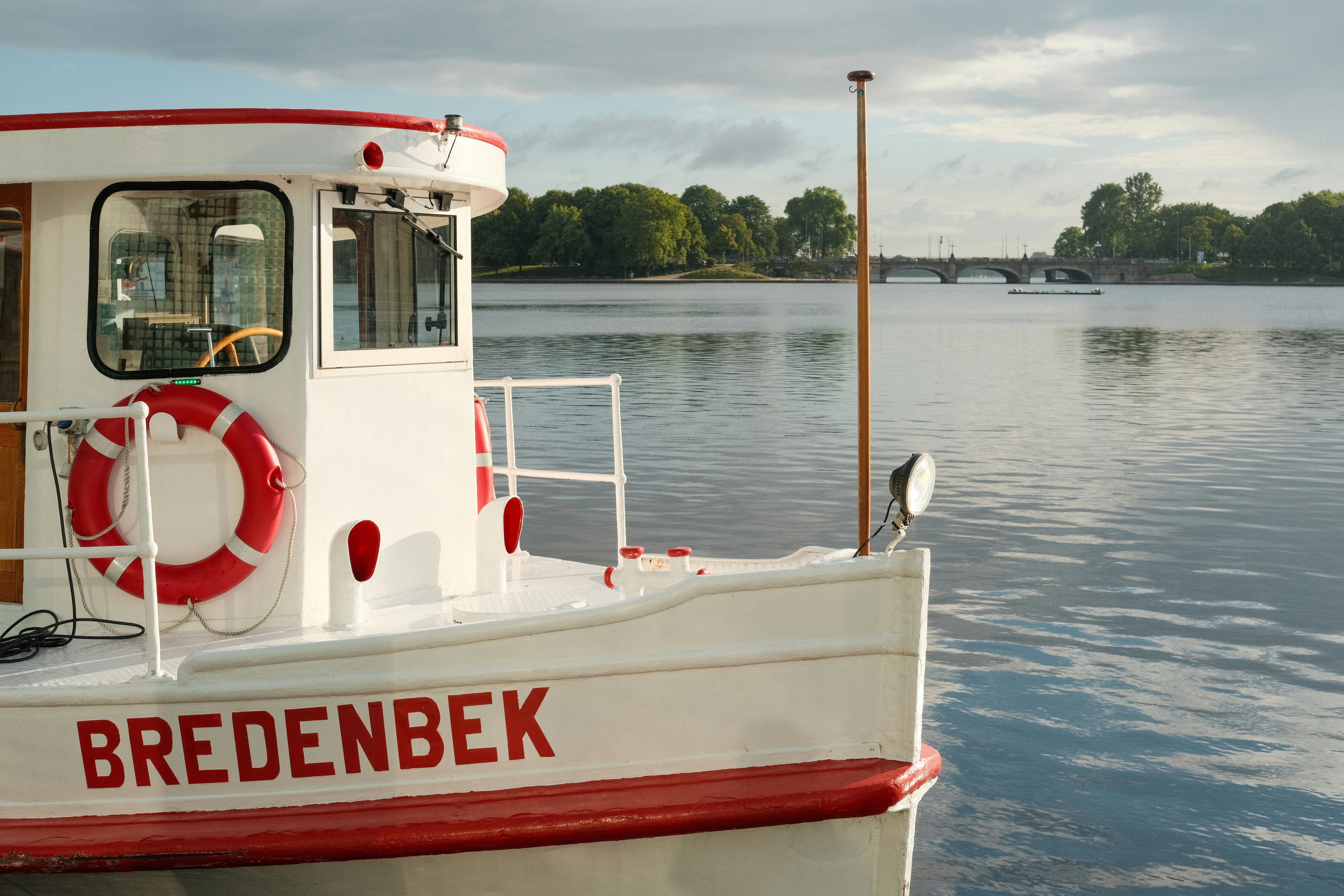 A red and white boat floating on top of a lake