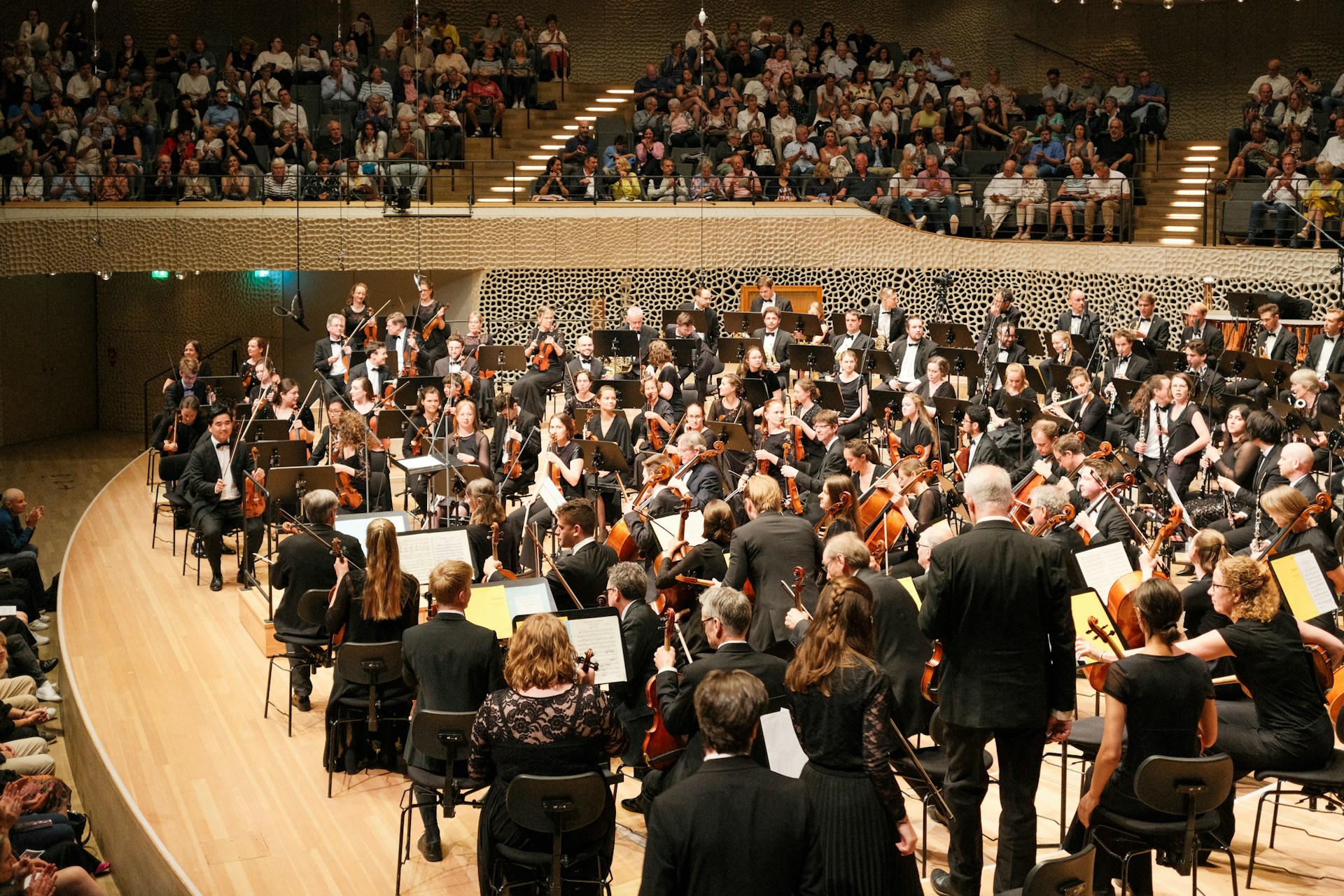 A conductor and orchestra performing in a concert hall