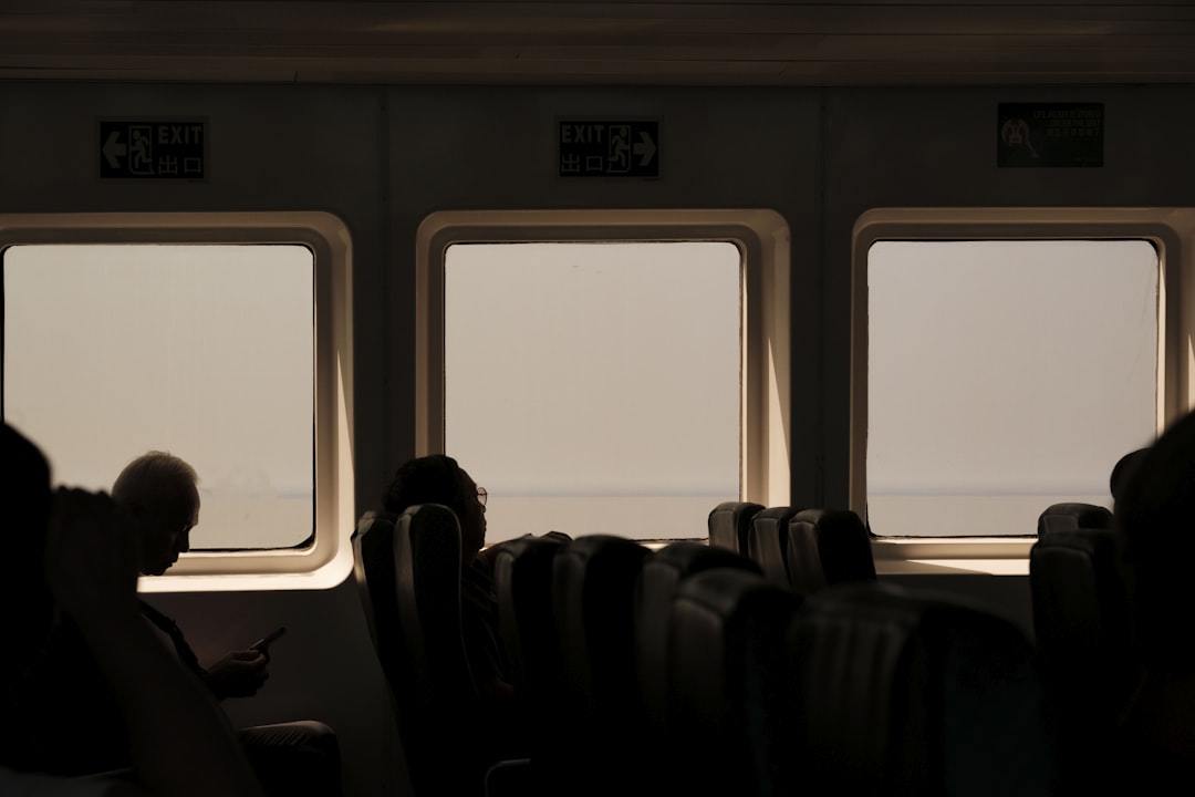 A group of people sitting next to each other on a train,