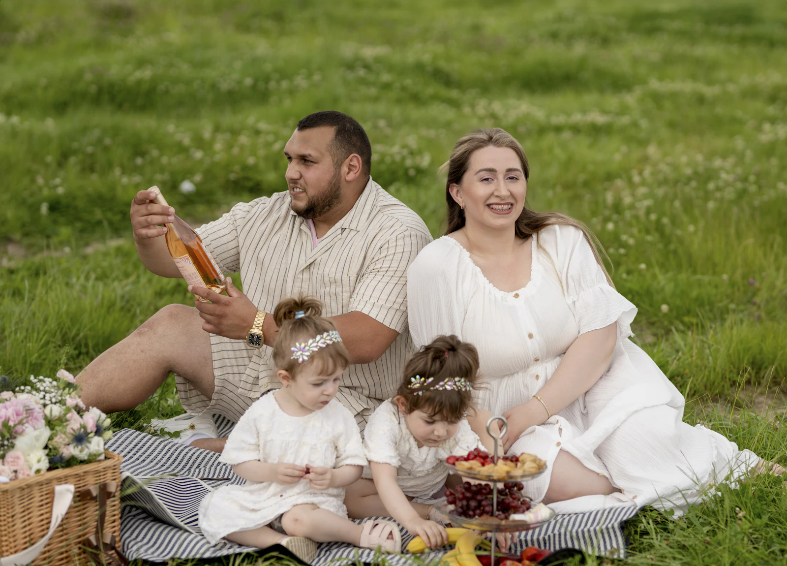 A family relaxing on a picnic blanket in a park