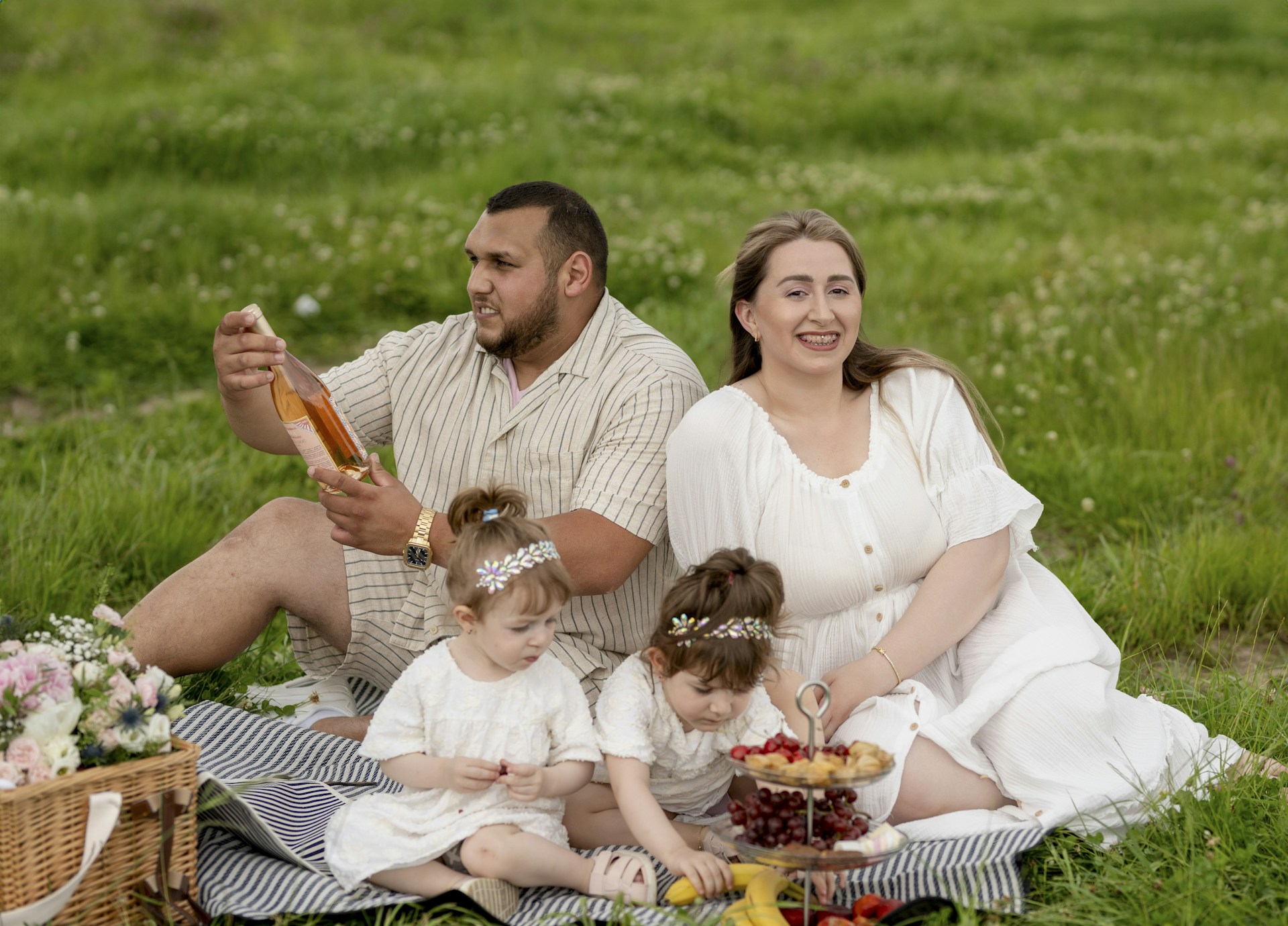 A family sitting on a blanket in the grass