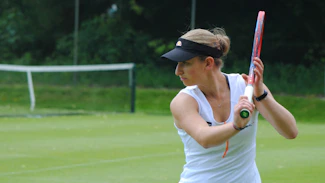 A woman holding a tennis racquet on a tennis court