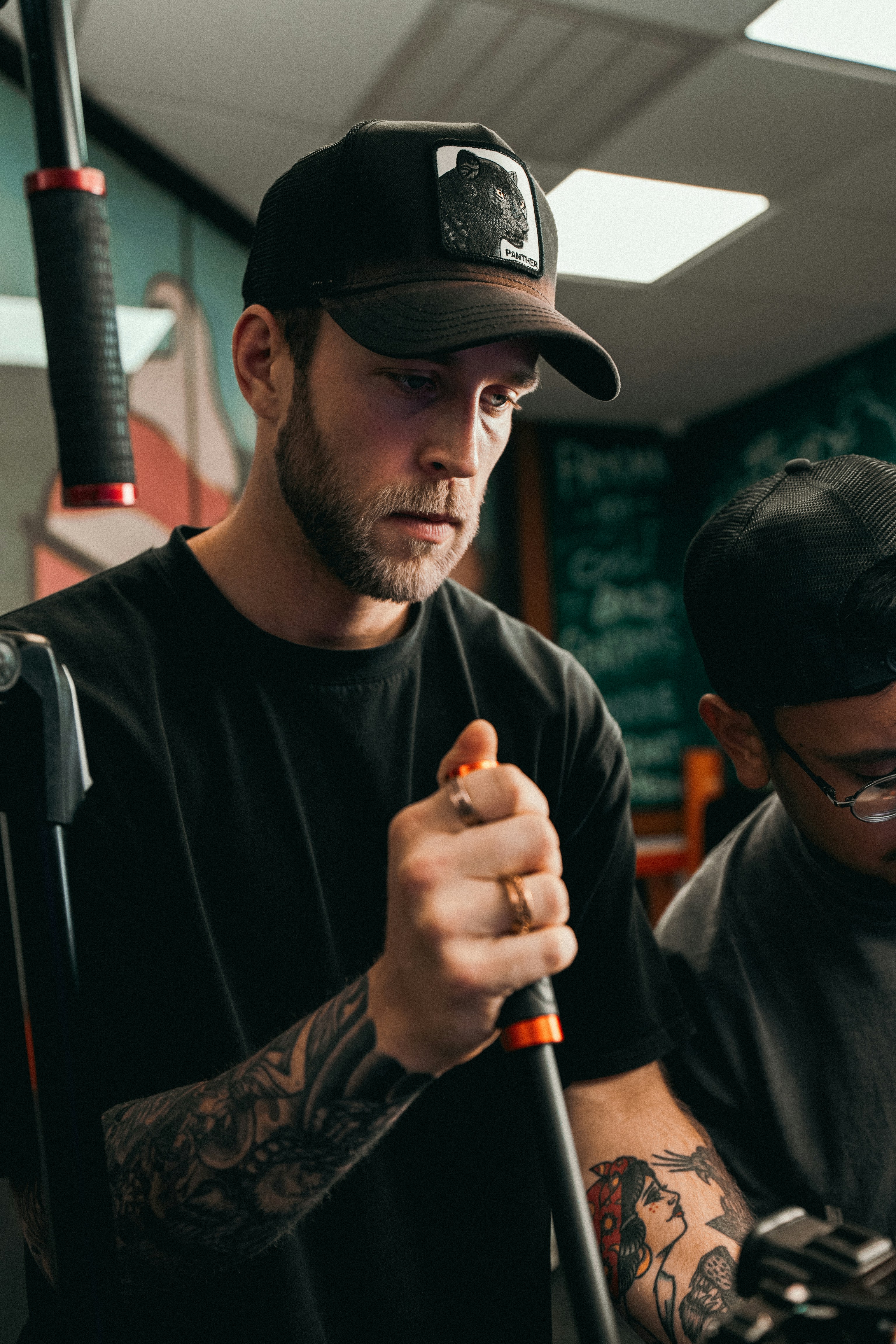 A man holding a baseball bat while standing next to another man