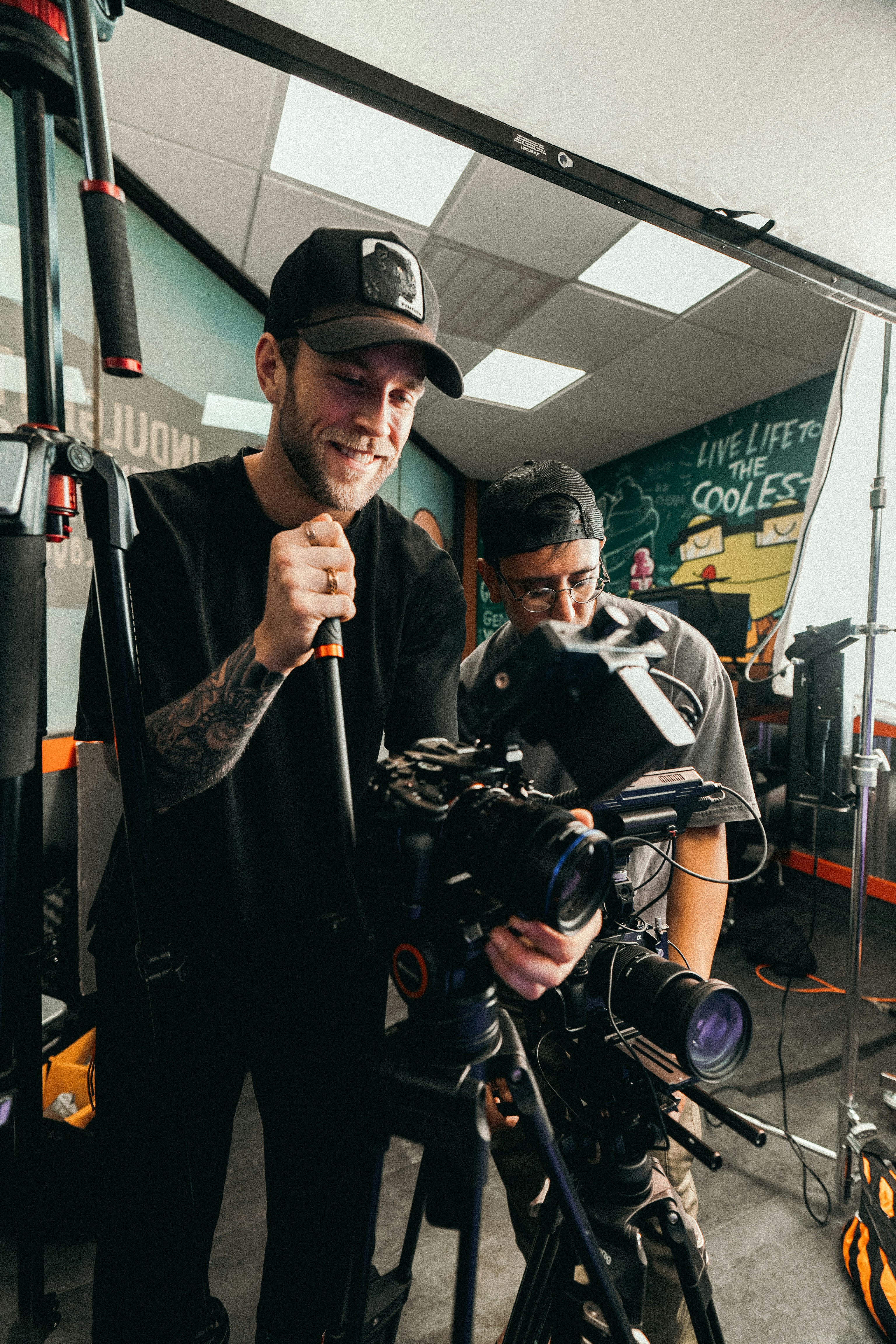 A man standing next to a camera in a room