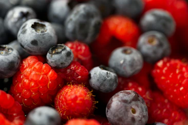 A close up of berries and blueberries in a bowl