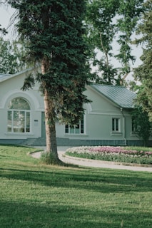 A white house sitting on top of a lush green field