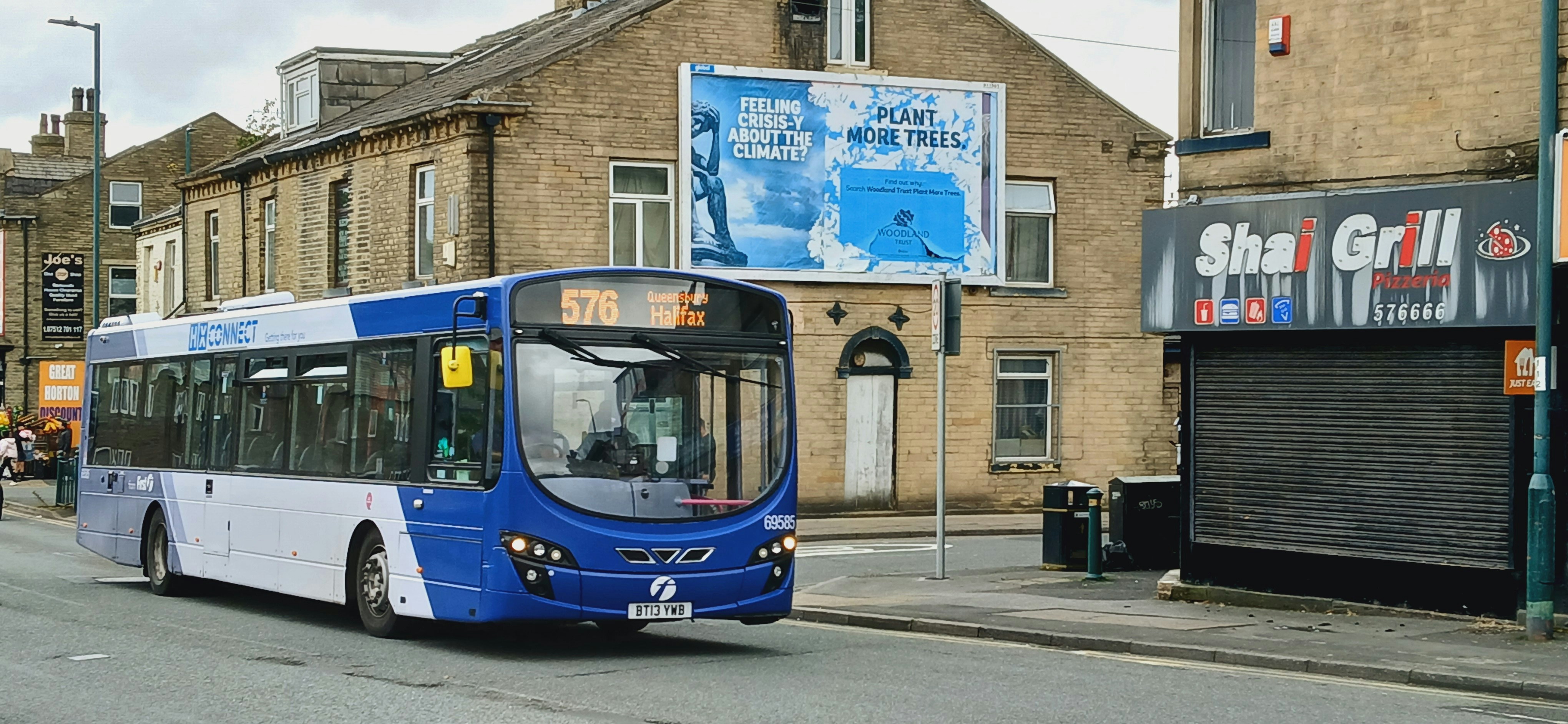 A blue and white bus driving down a street