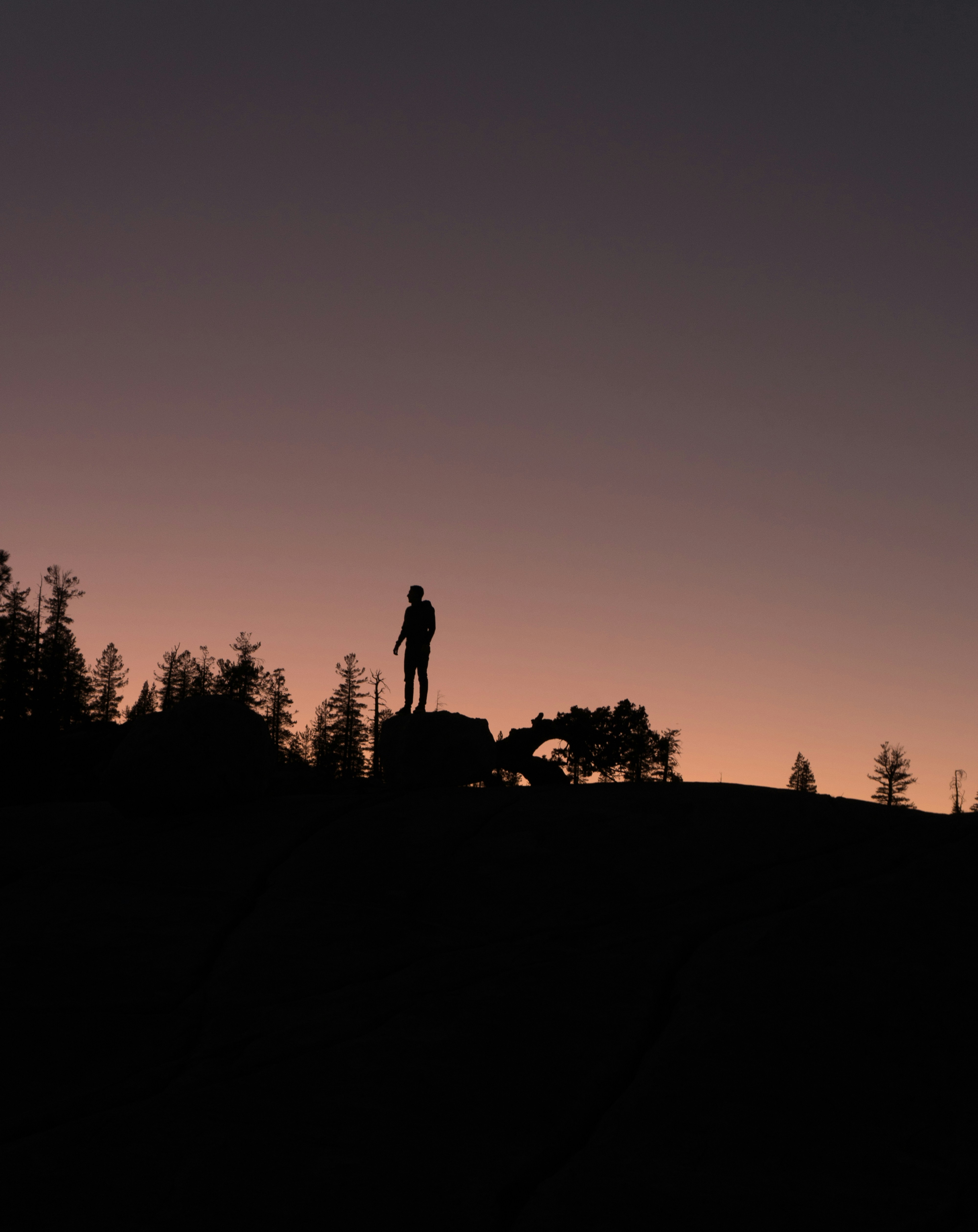 Silhouette of a person on an oreum hilltop at dusk