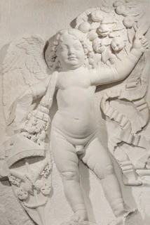 Marble sculpture of a winged cherub holding fruit