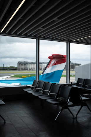 An airport terminal with chairs and a large window