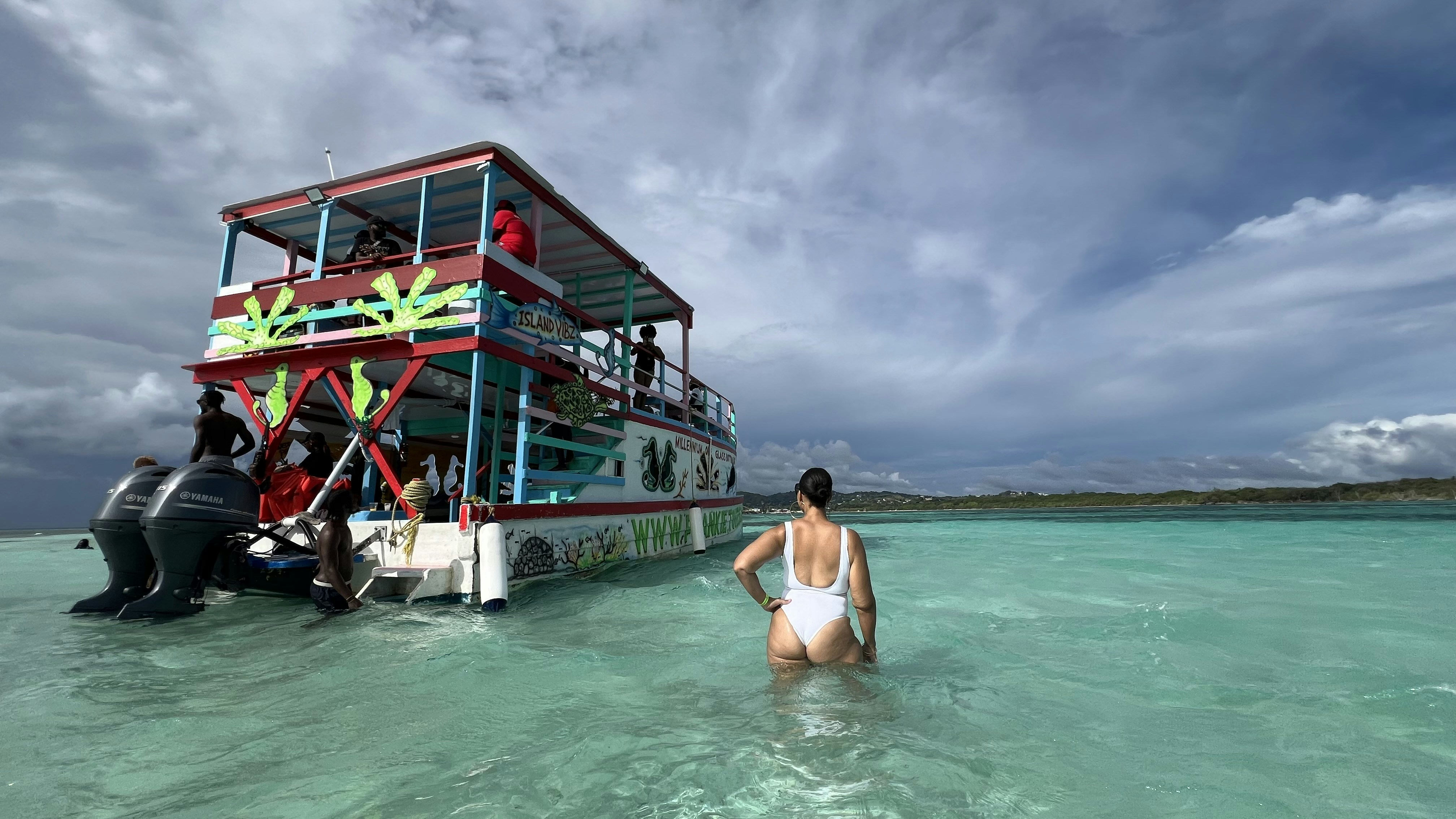 A woman standing in the water next to a boat