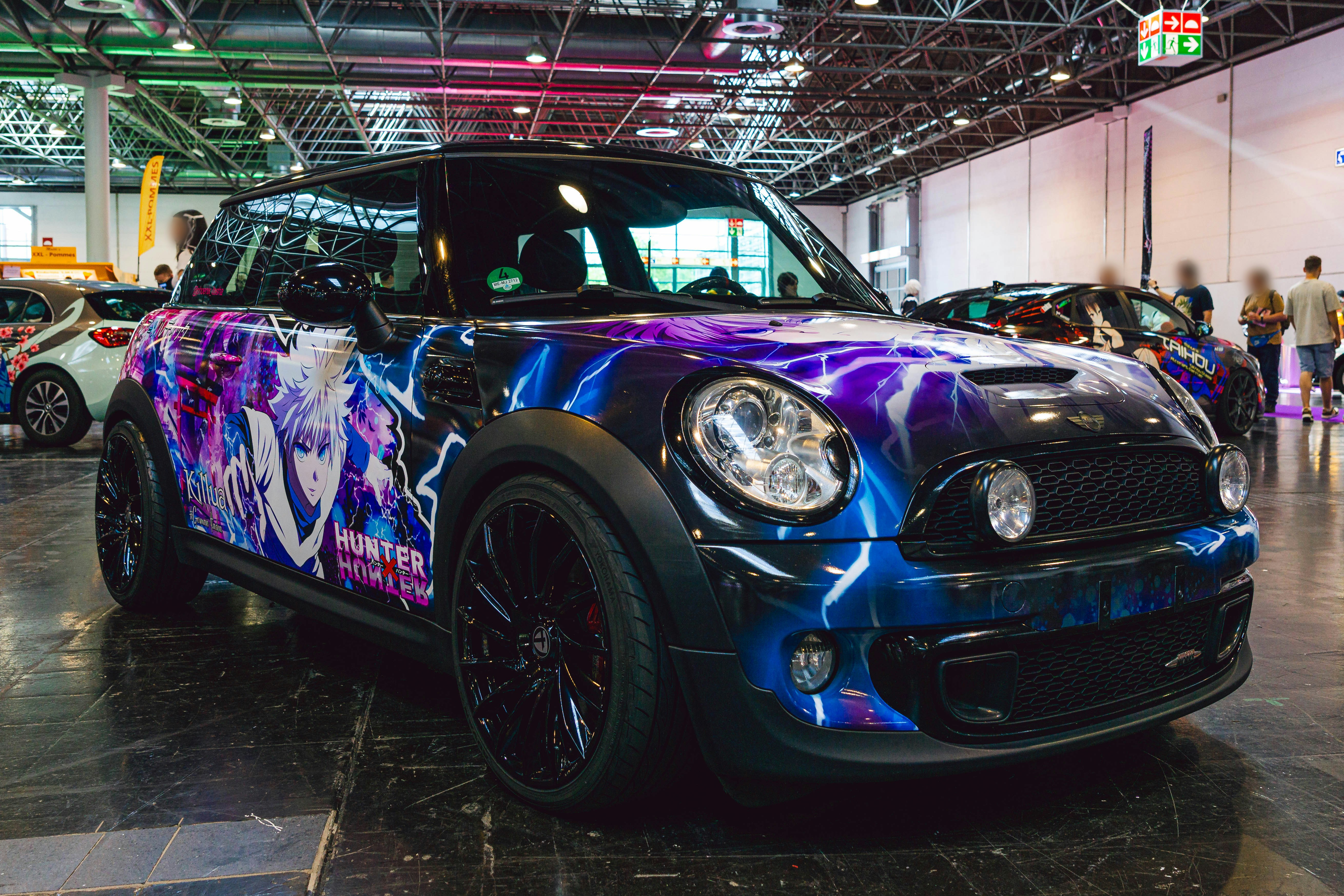 A mini car with a colorful paint job parked in a showroom
