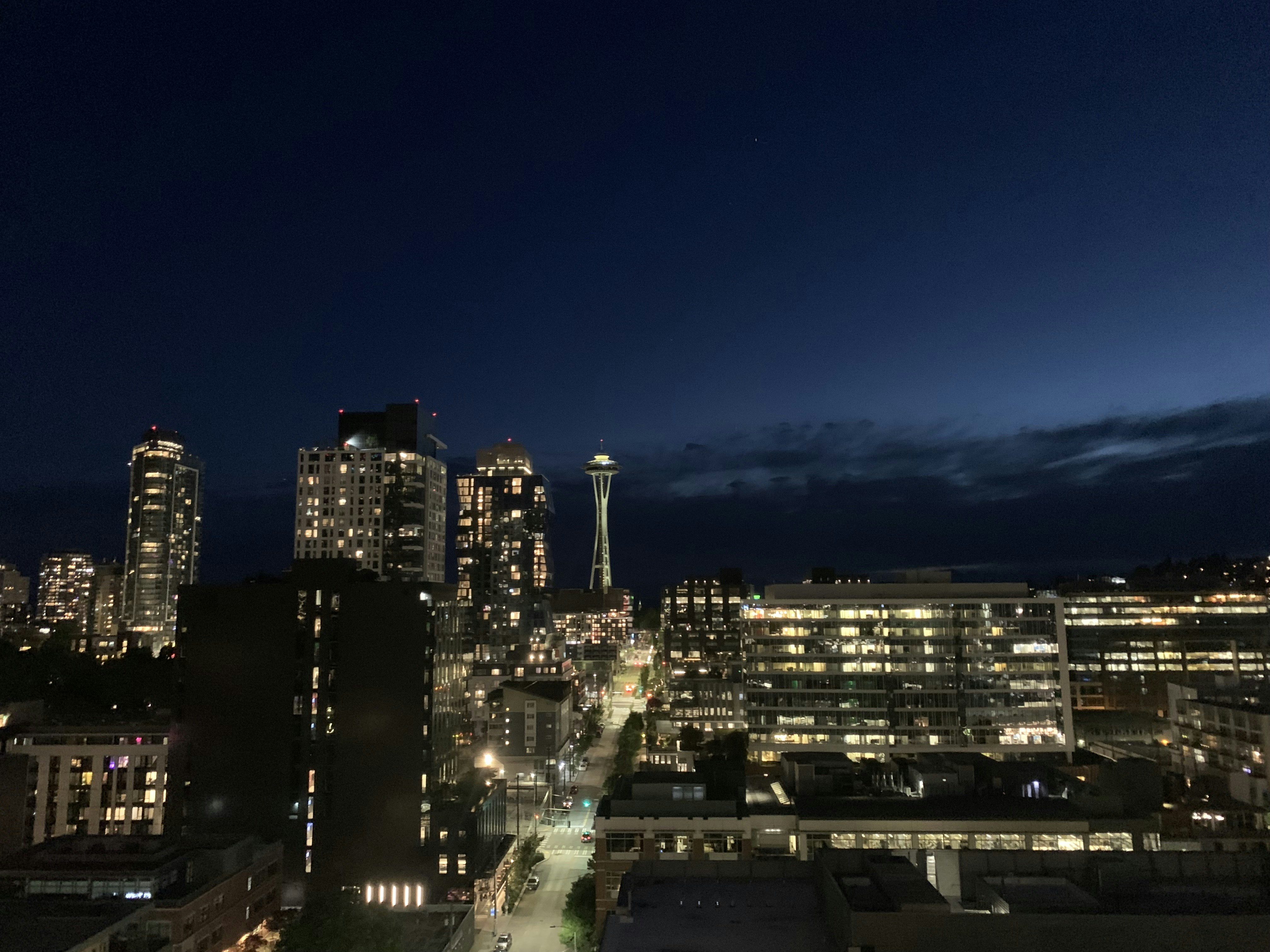 Ein Blick auf eine Stadt bei Nacht von der Spitze eines Gebäudes