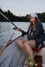 A woman sitting in a boat with a fishing rod