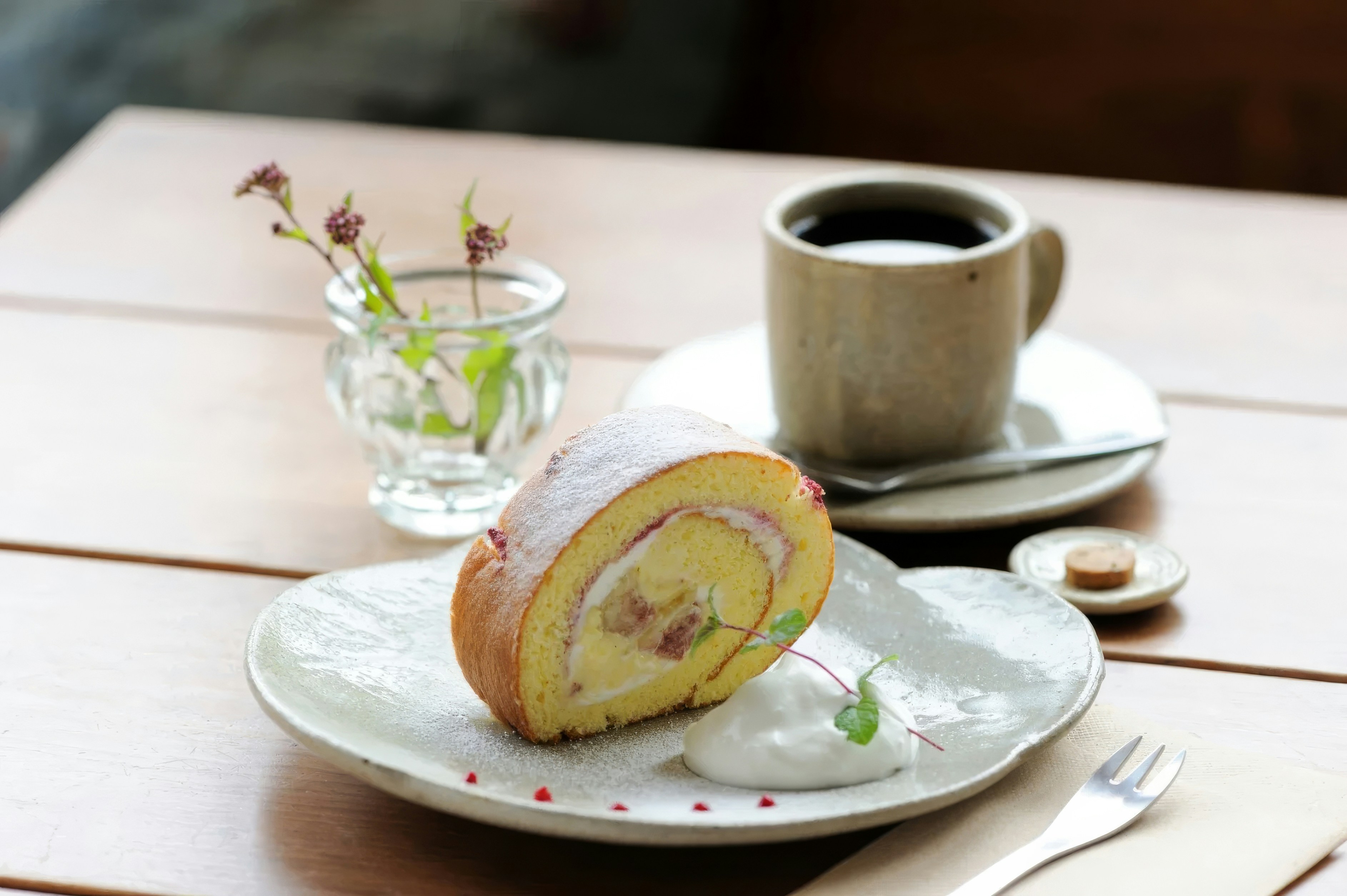 A plate with a pastry on it next to a cup of coffee