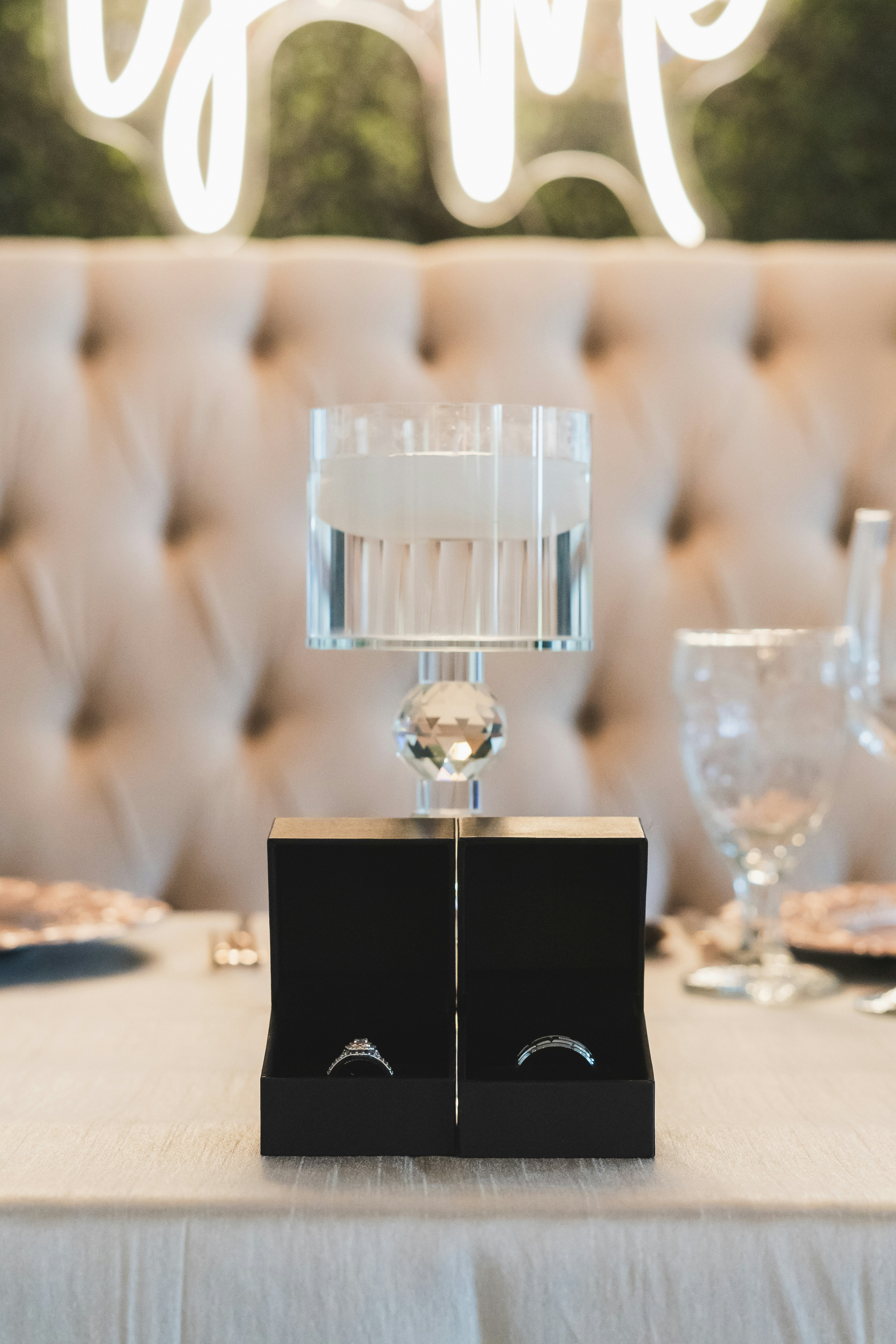 A table with a white table cloth and a light up sign