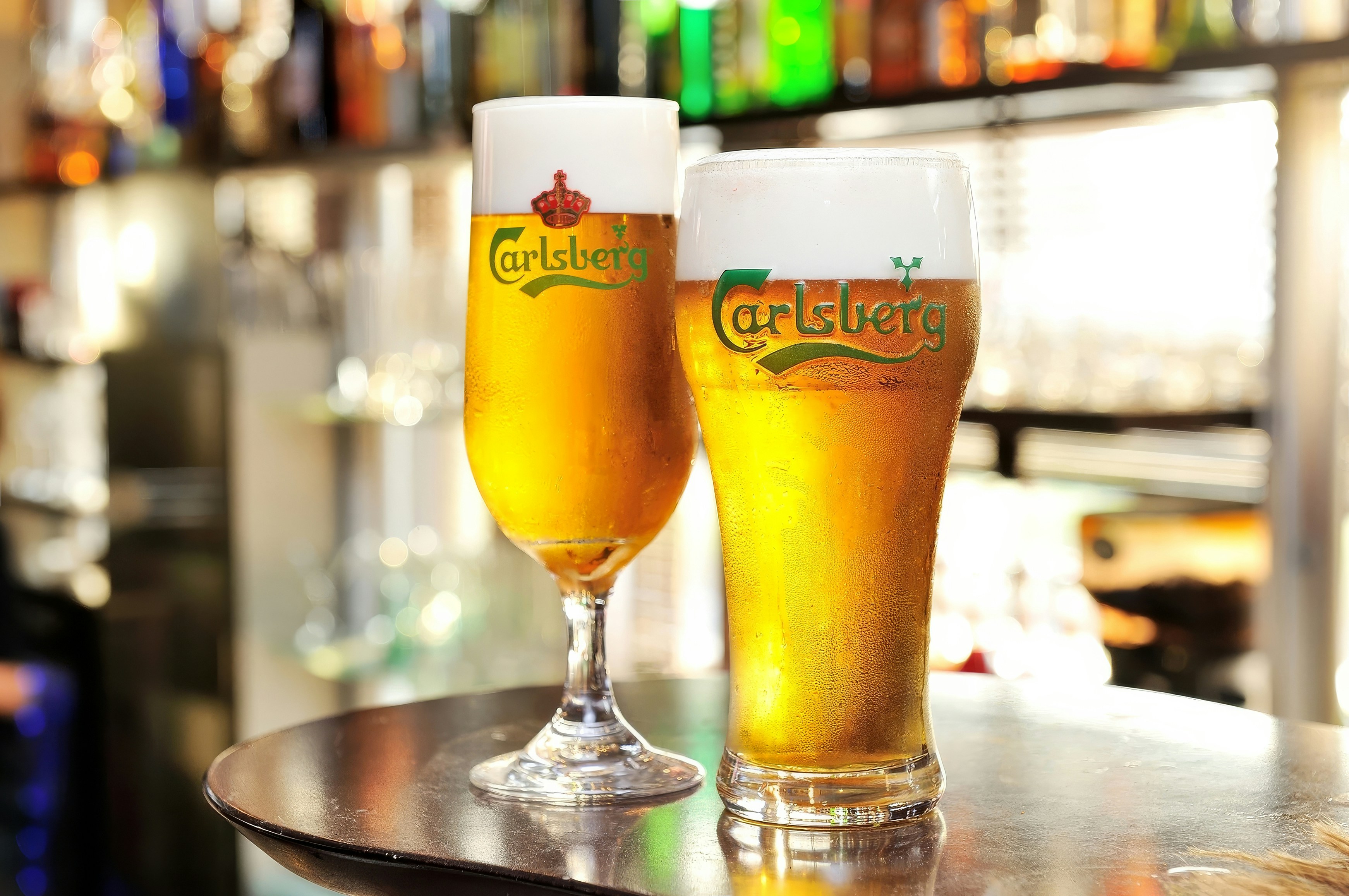Dos vasos de cerveza en la barra de un bar