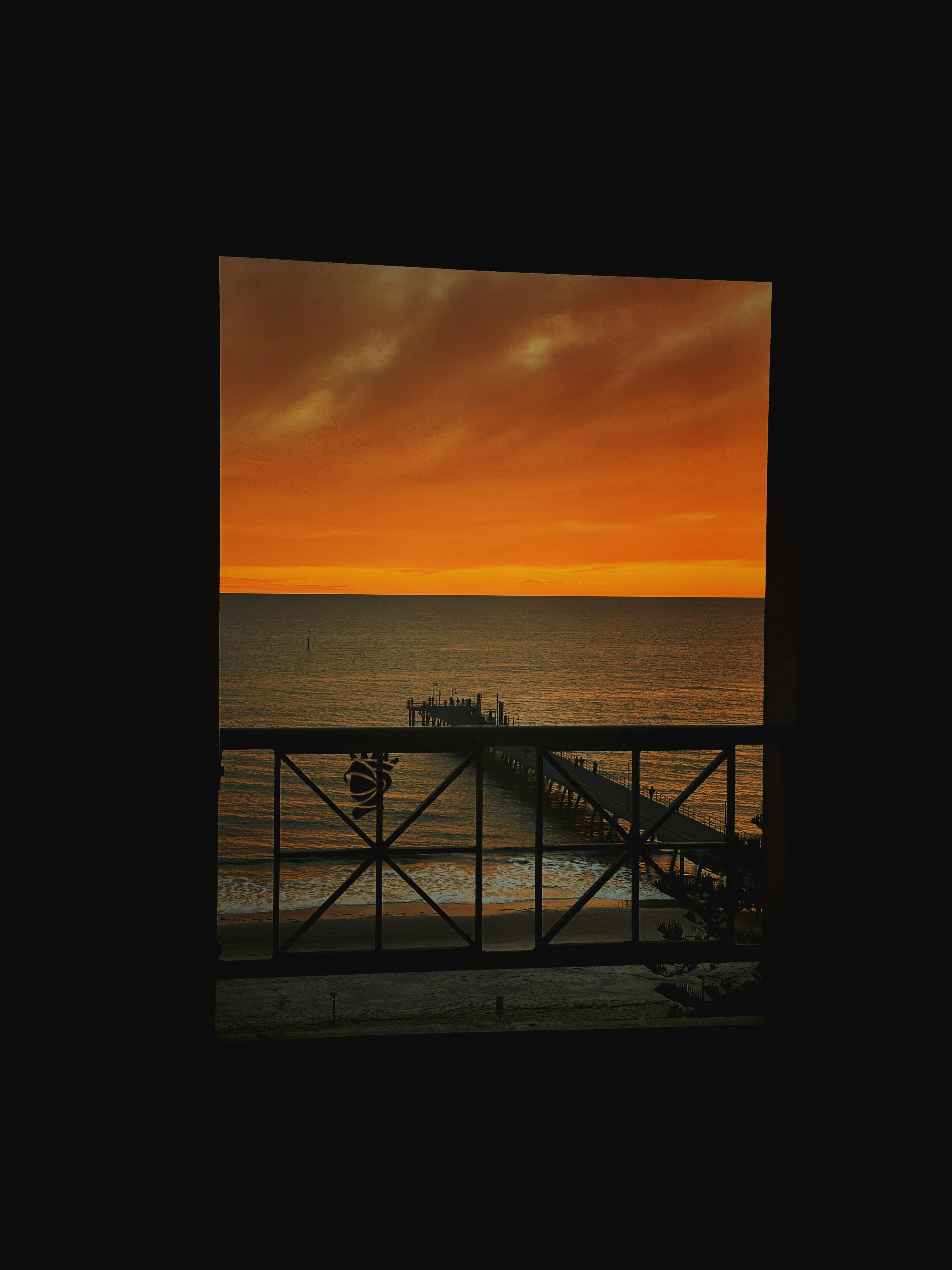 A view of a sunset over the ocean from a balcony
