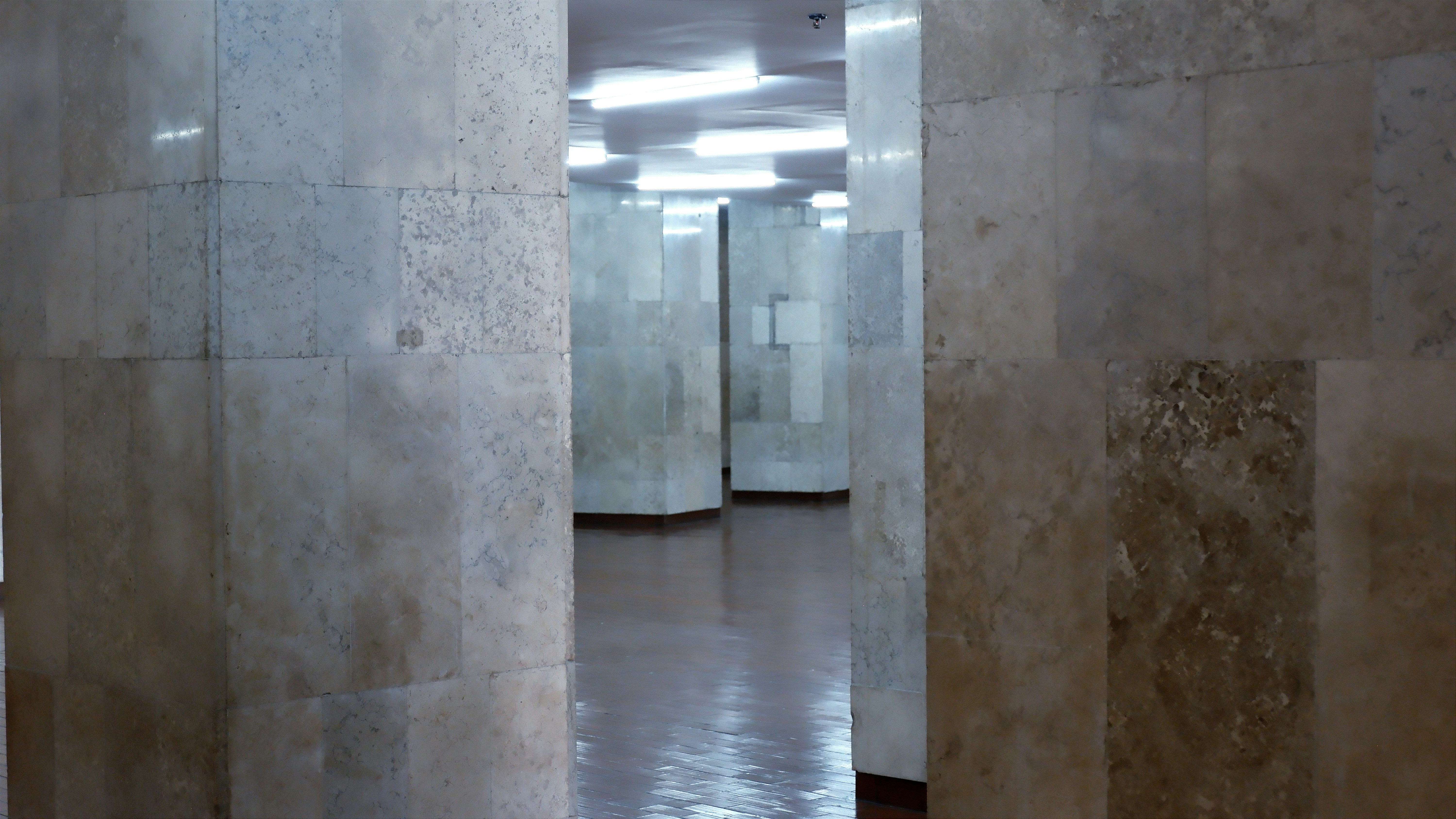 A hallway with a bunch of pillars and a clock