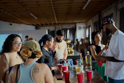 A group of people standing around a bar